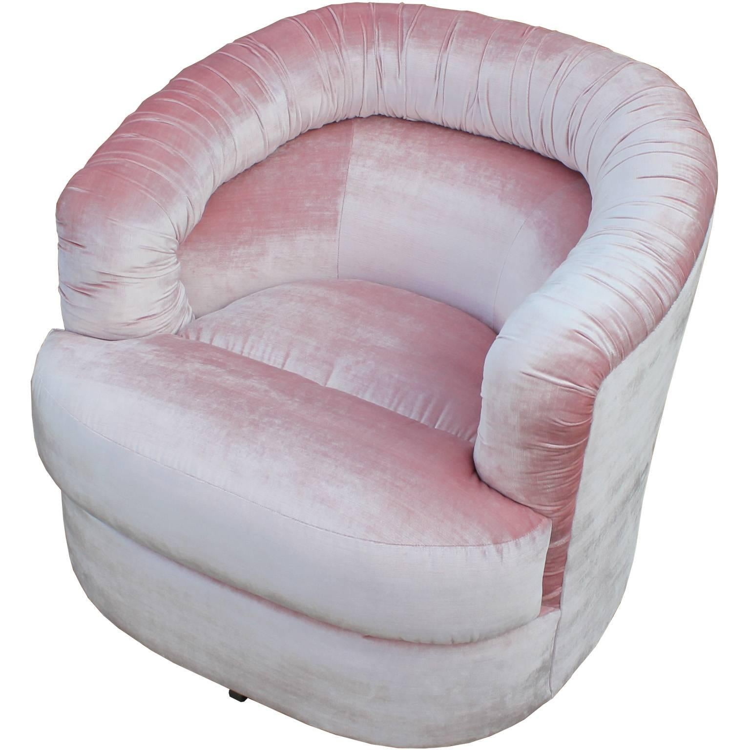 Stunning pair of ultra luxe and comfortable swivel chairs. Chairs are freshly upholstered in a silky pale pink velvet. A ruched or pleated back adds visual interest to the clean lined piece. Perfect in a modern, Hollywood Regency, or Mid-Century