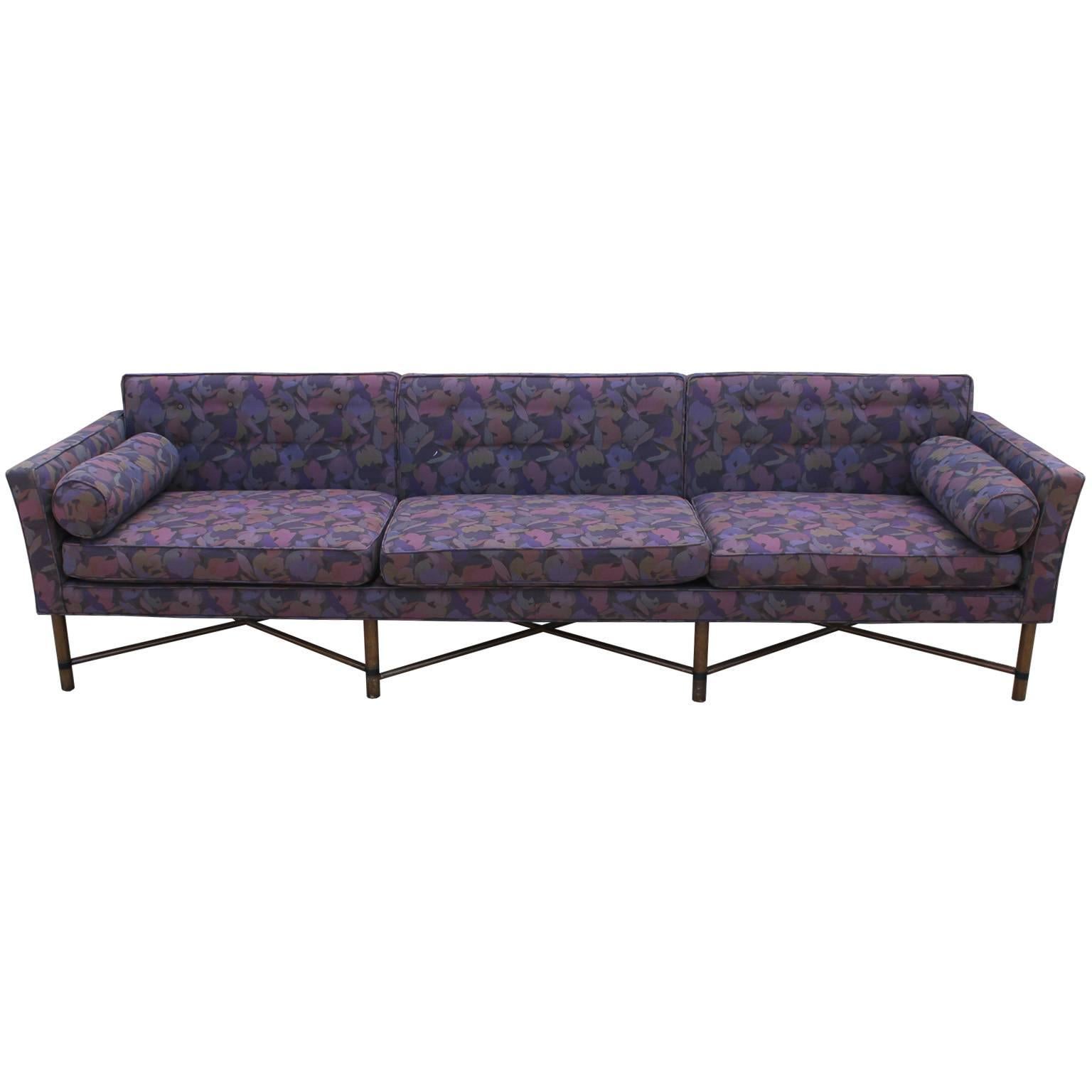 Stunning and rare custom seating group by Harvey Probber. Seating group includes three seat sofa, loveseat. Both sofas feature criss cross stretchers with brass accents and bolster pillows. Sofas are upholstered in a vintage purple floral.
The