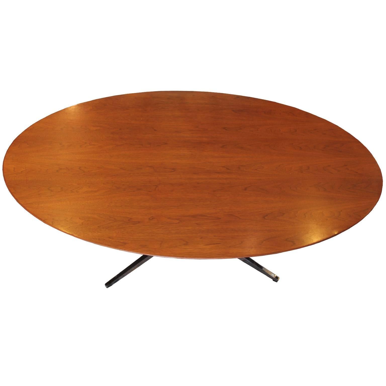 Oval shaped dining or conference table designed by Florence Knoll. Walnut top has beautiful graining. Iconic chrome base. The chrome has some wear to the feet of the base noticeable when up close. The top is in nice vintage condition with slight