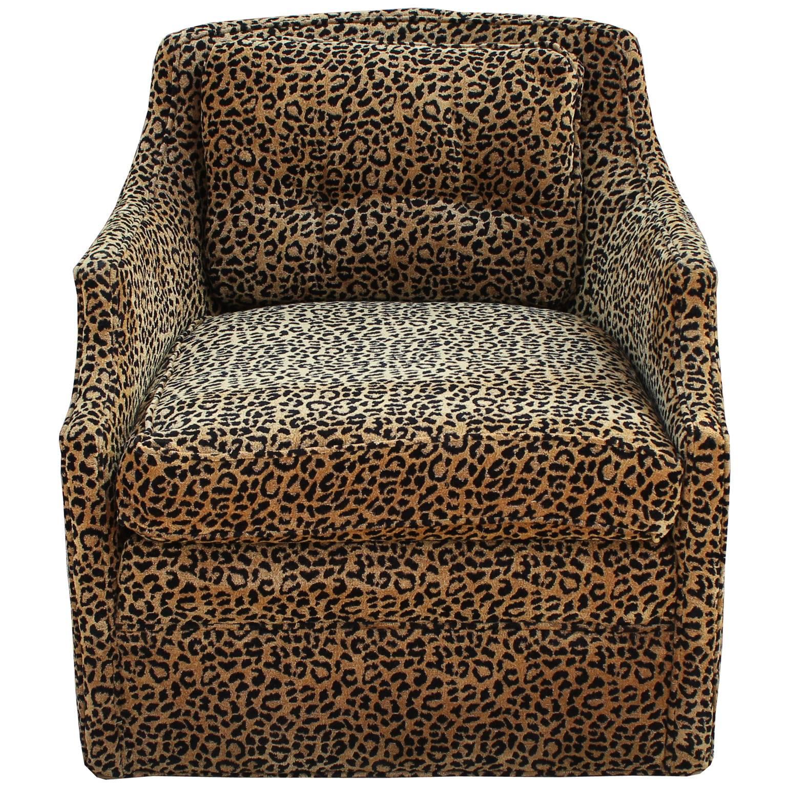 Luxe pair of swivel armchairs attributed to Baker Furniture. Chair backs have gently curved, feminine lines. Upholstered in a textural leopard fabric. Perfect in a transitional, traditional, or Hollywood Regency space. Fabric is vintage but has no
