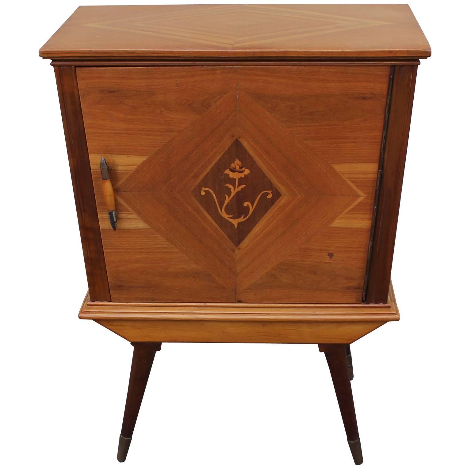 Pair of sophisticated and intricate Italian nightstands or bedside tables. Tables feature beautifully inlaid wood. Cabinets front feature a flower motif. Brass and wood spear pull. Tapered and splayed legs capped in brass complete the piece.