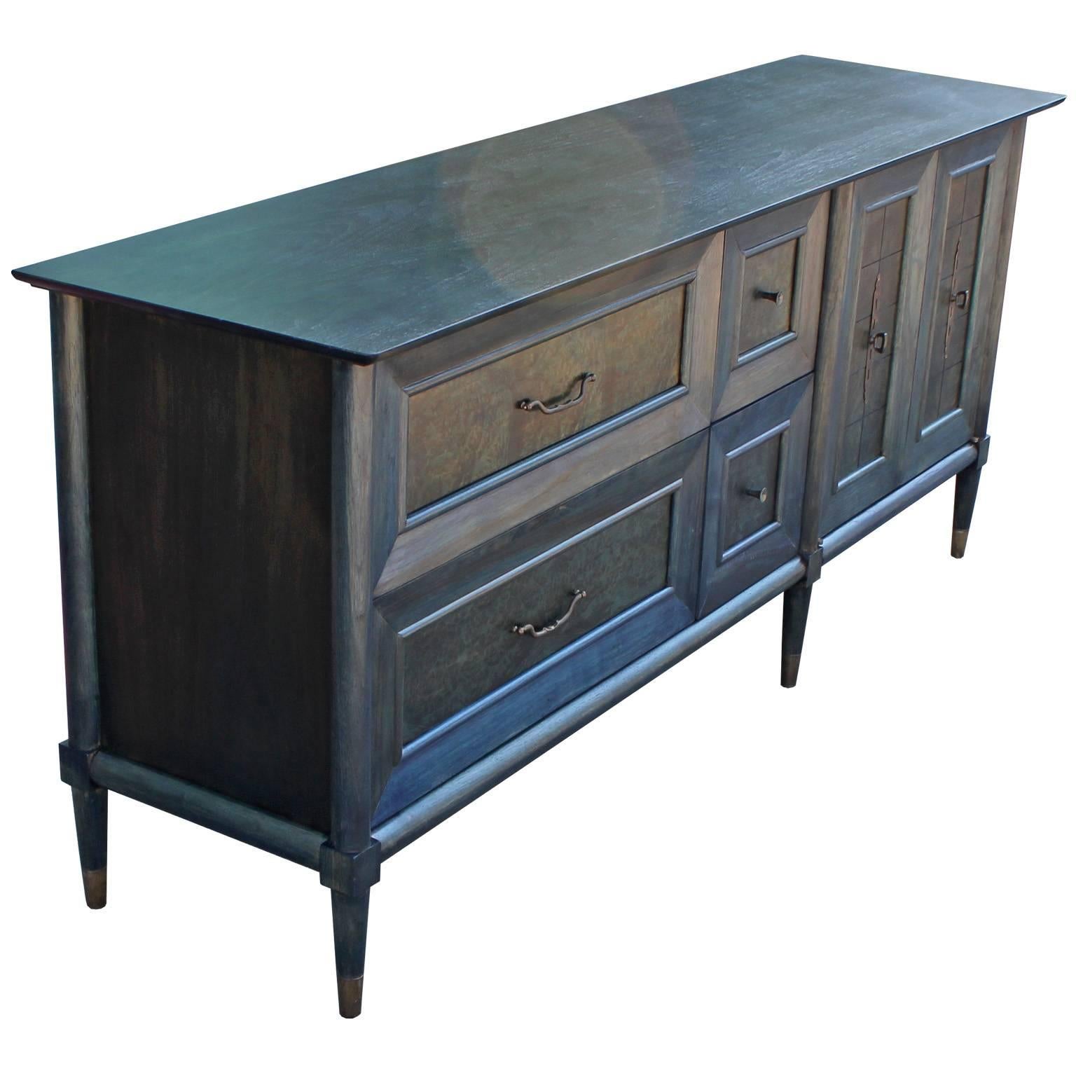 Glamorous Hollywood Regency style sideboard or credenza. Burl wood sideboard is freshly finished in a denim blue aniline dye. Copper hardware has a wonderful patina. Sideboard has excellent lines and sophisticated detailing. Four drawers and an open