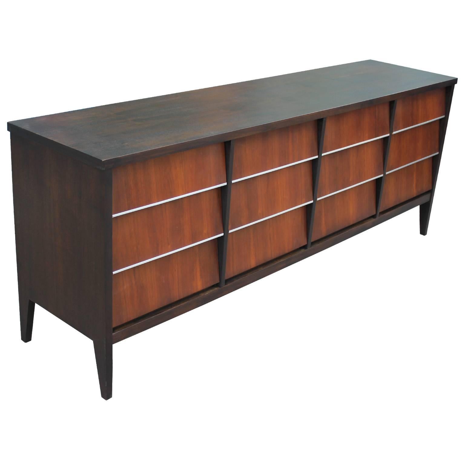 Bold a stylish 12 louvered drawer American Mid-Century Modern dresser. Dresser is freshly finished with a dark walnut case and medium walnut drawer fronts. Drawers are accented with lovely aluminum strips. Twelve drawers provide excellent storage