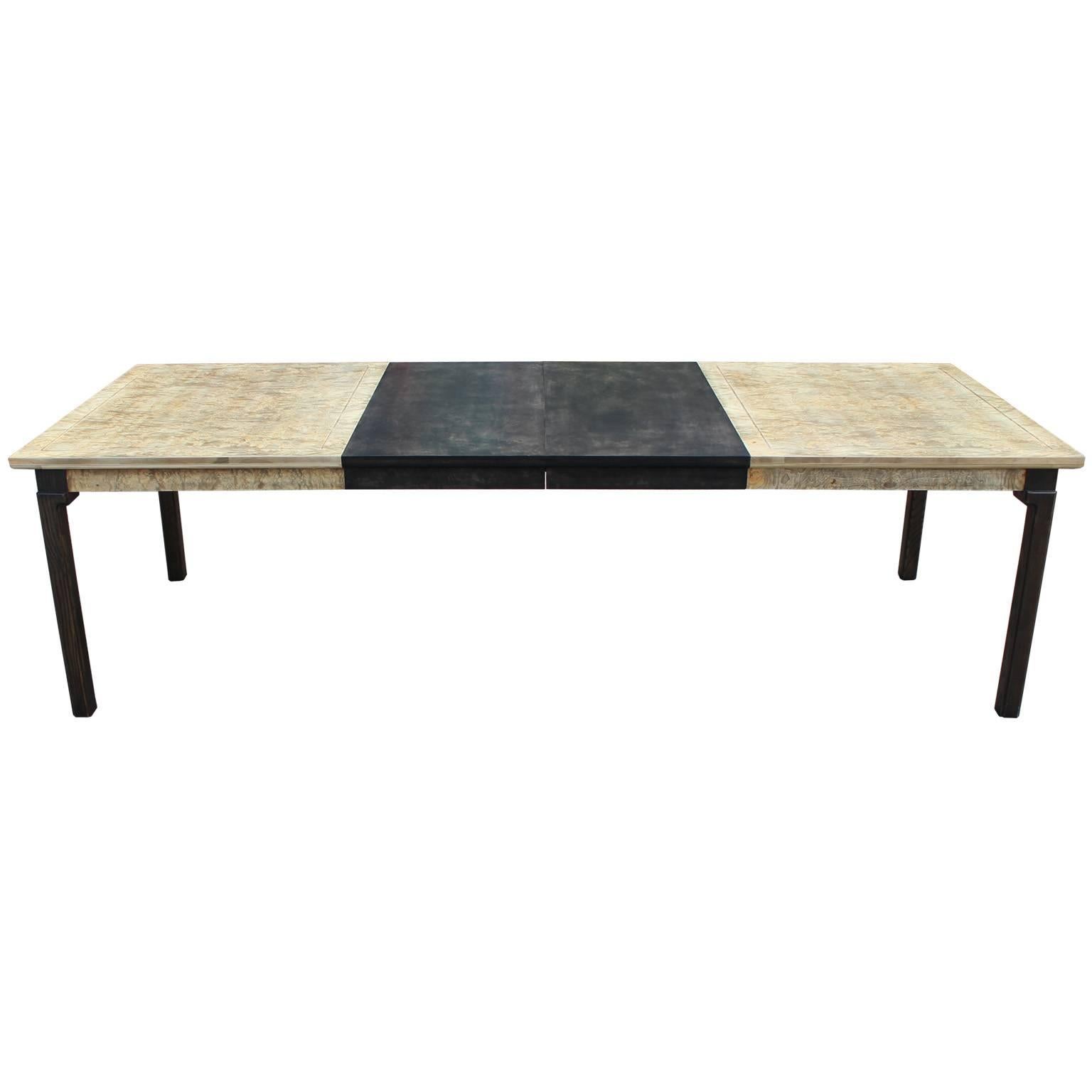 Striking burl wood dining table with two leaves. Tabletop is a dramatic, cool blonde burl with excellent graining. Two leaves are finished in a dark walnut to match the legs. Burl table tops have an incised border. The Table is absolutely gorgeous