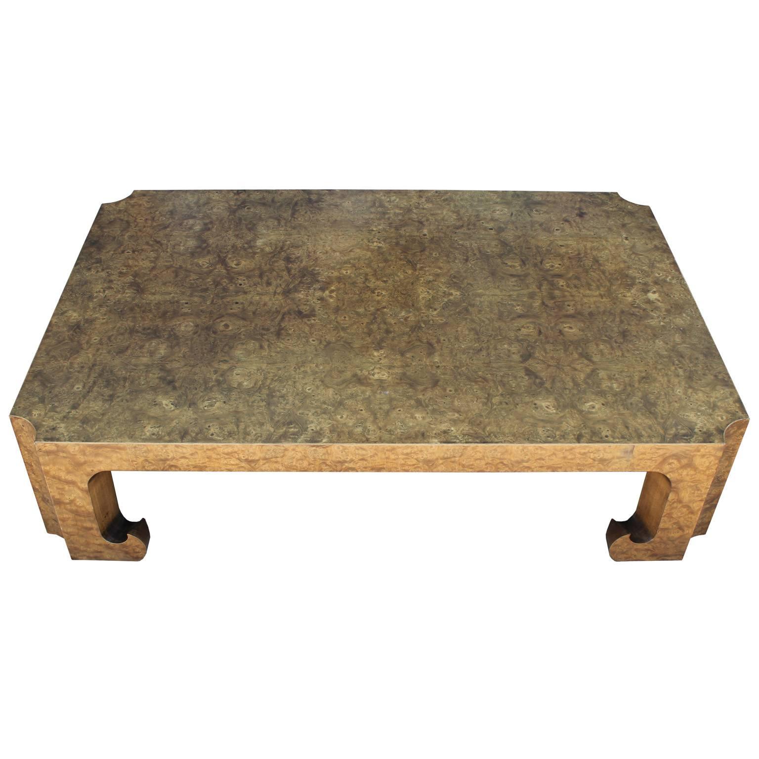 Luxe coffee or cocktail table by Baker Furniture. Coffee table is in a dramatic, golden hued Carpathian burl elm. Table has beautiful Asian influenced lines with scalloped corners, chunky legs, and curled feet. Table would be excellent in a