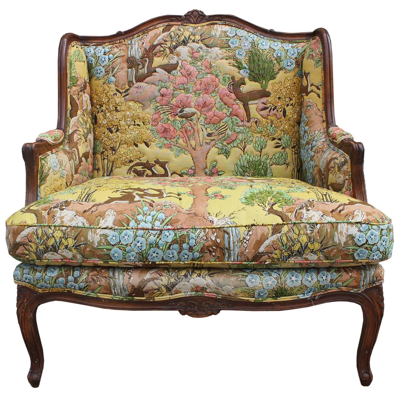 Great looking extra wide French Bergere chair with interesting wildlife upholstery. The chair was probably made in mid to early 20th century. The carvings are nice and crisp and the fabric is bold. The fabric has stitching around some of the