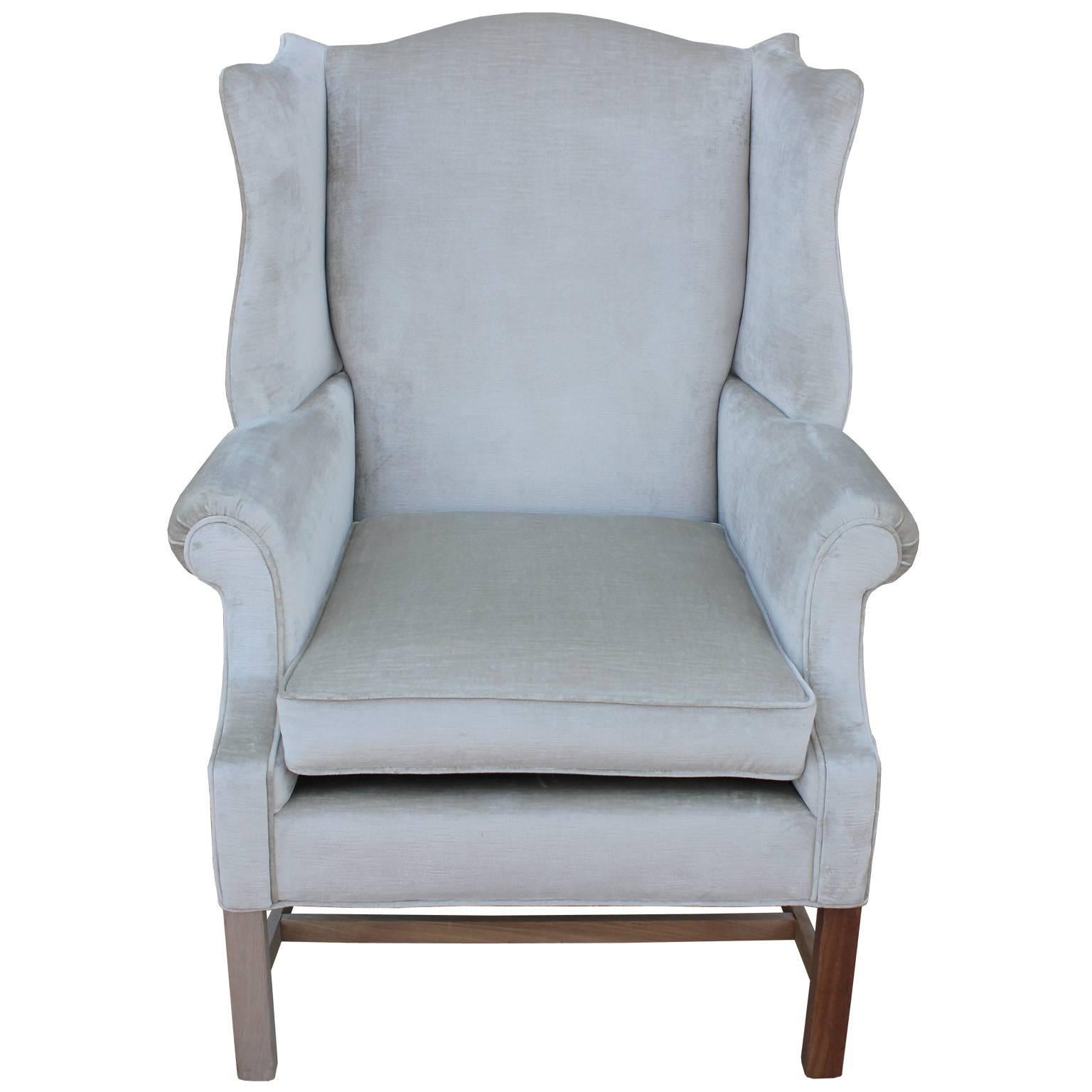 Fabulous pair of wingback lounge chairs. Chairs have incredible, sculptural lines. Freshly upholstered in silver grey velvet. Chairs rest stripped and bleached legs Due to the variation in wood one leg is slightly darker than the rest on one chair.
