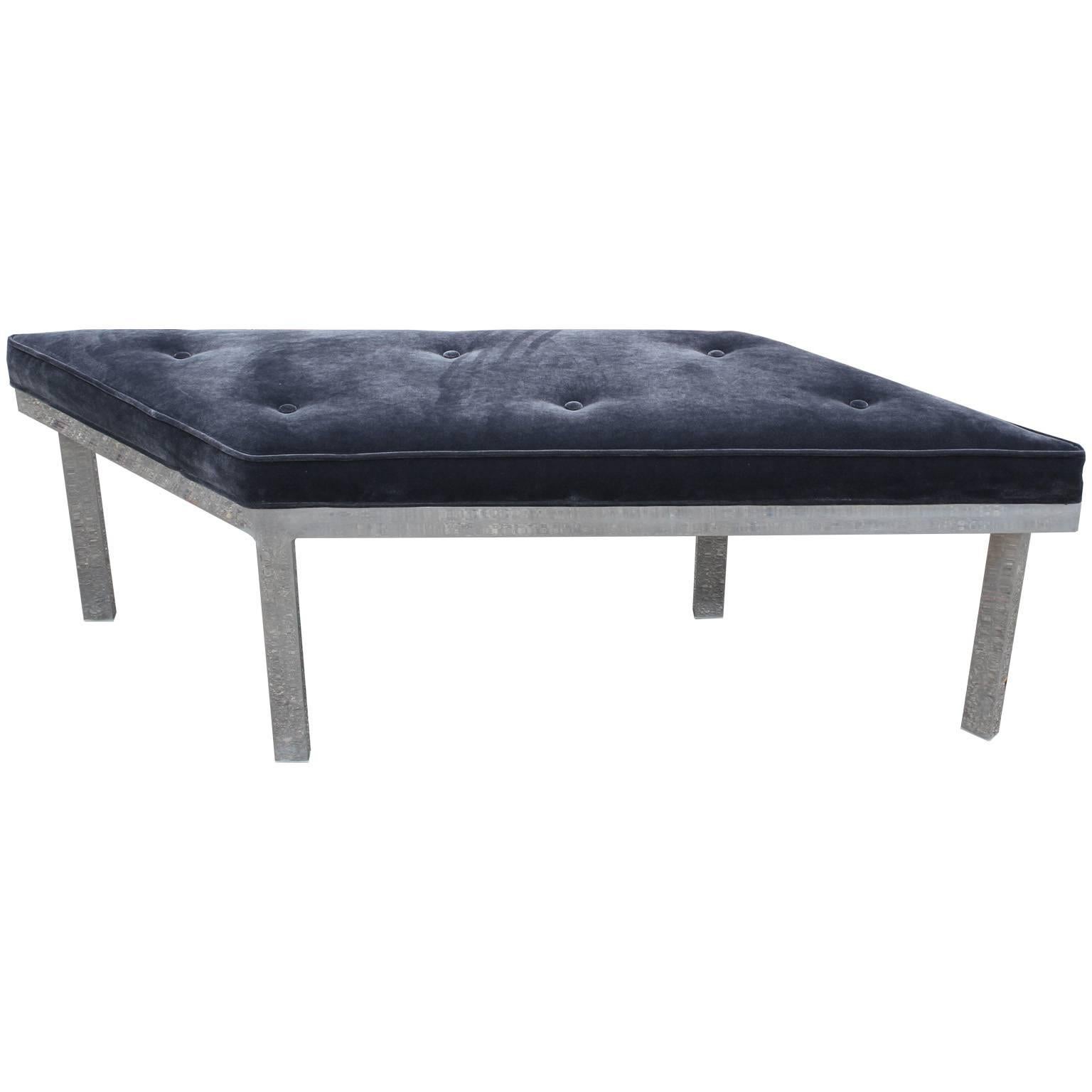 Fabulous parallelogram shaped bench or ottoman. Freshly upholstered in a lightly tufted grey velvet. Aluminium base. Would be perfect used as a coffee table as well.