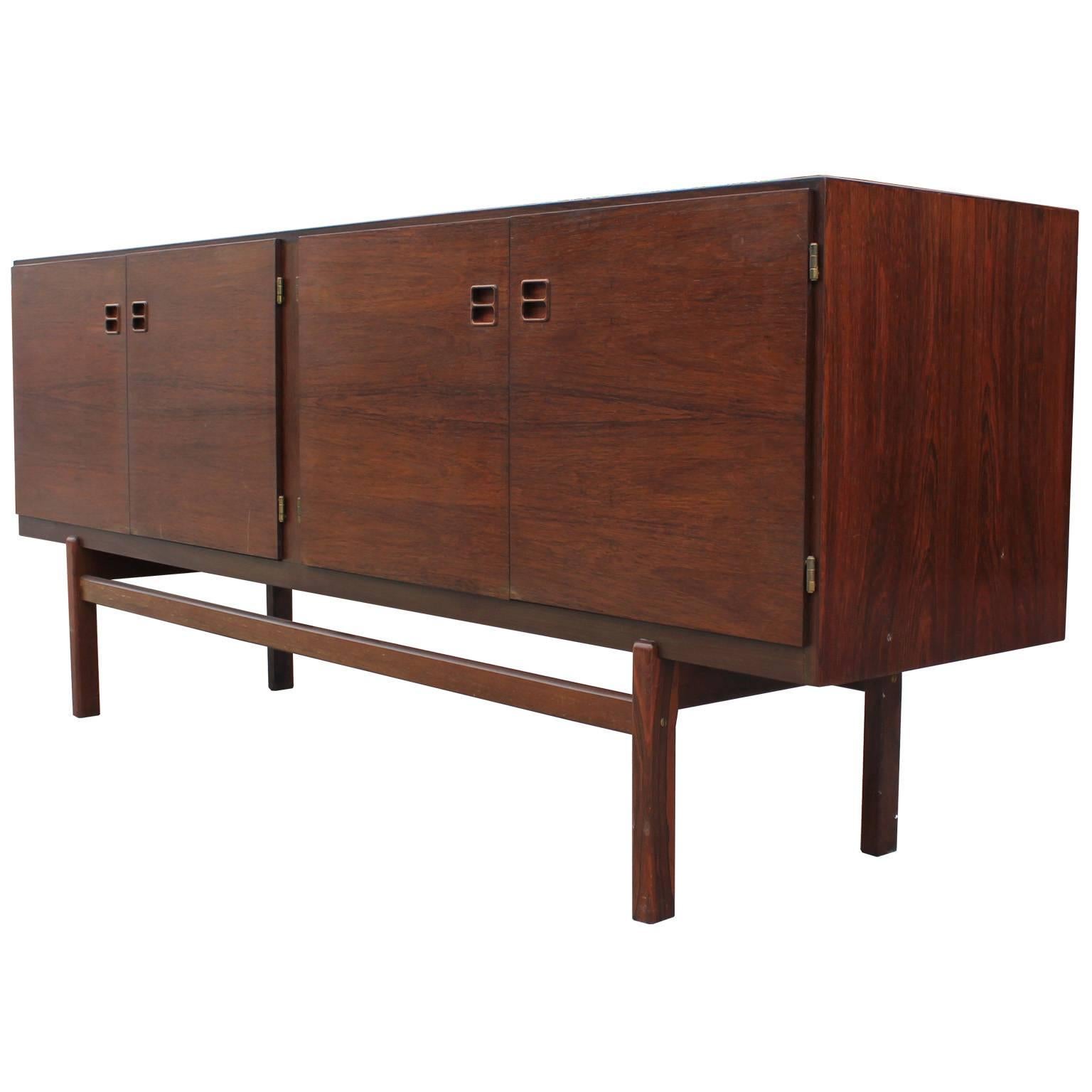 Clean lined Danish rosewood sideboard with four doors and lots of storage space. This wonderful cabinet floats above a thin base. The balance feel of this credenza has a great feel and would be a great addiction to any room.