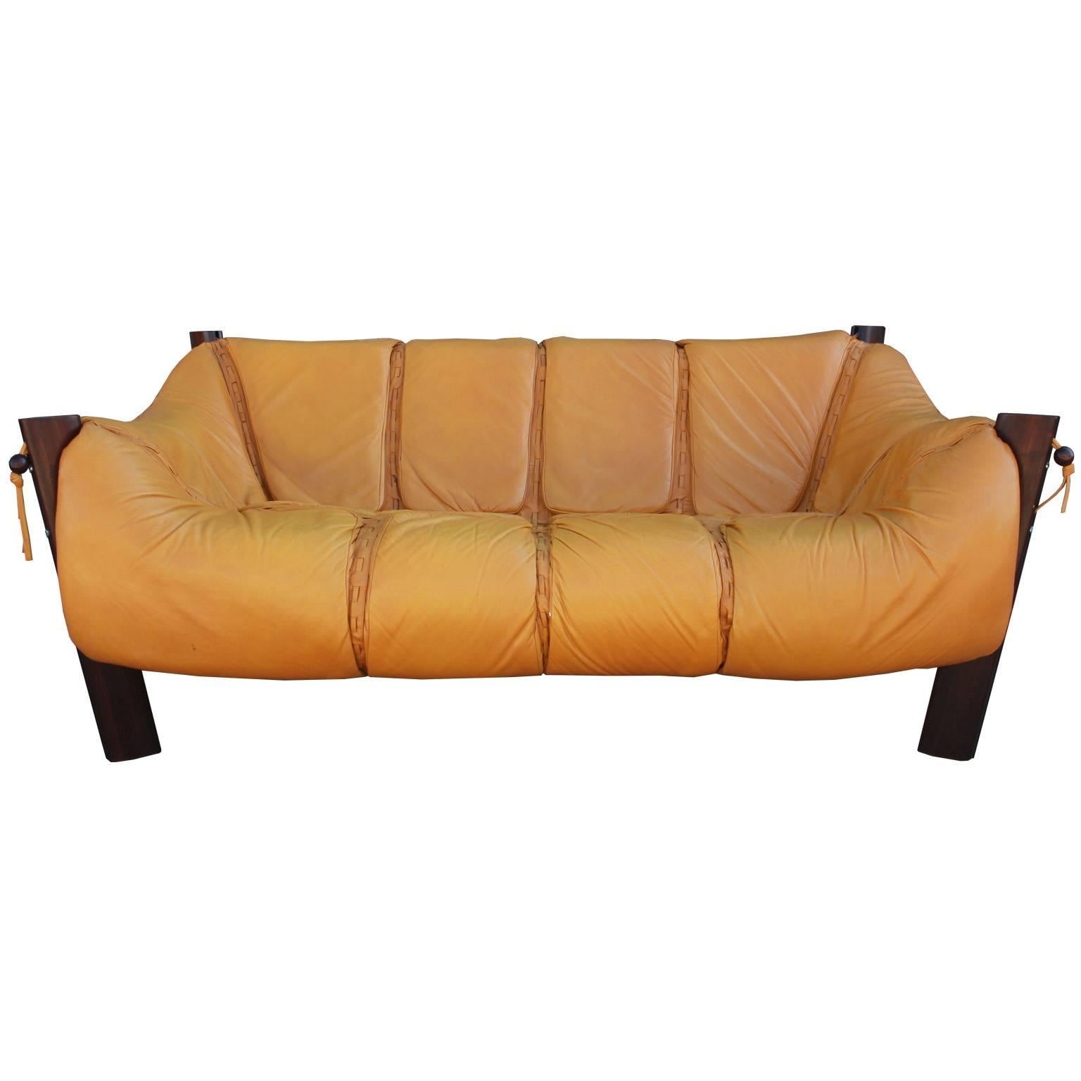Wonderful Percival Lafer loveseat or sofa in a supple soft mustard yellow leather. It has a wonderful design and lots of detail work. In the corners the seats are secured by a leather strap and rosewood ball. There is one small minor flaw in the