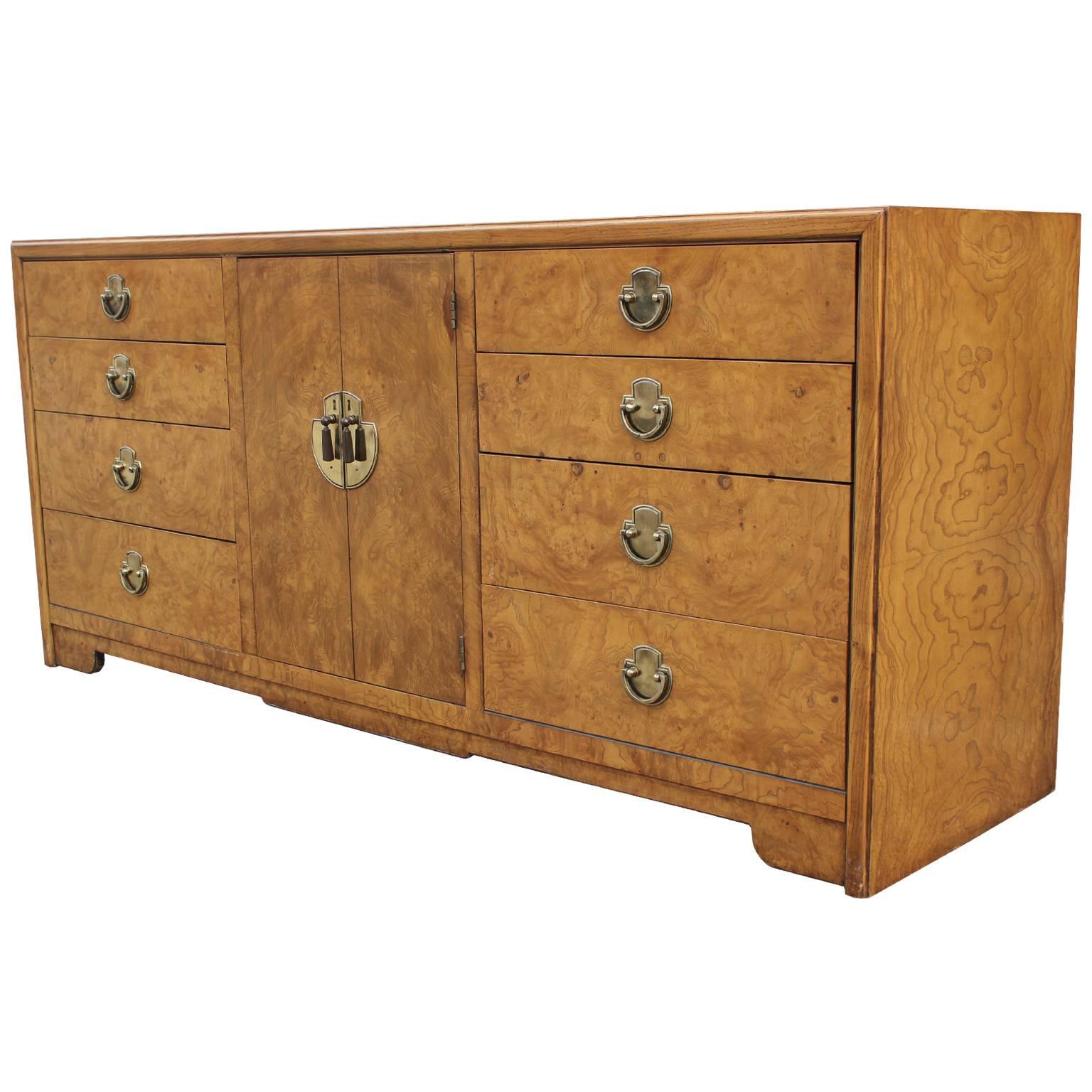 Modern burl and brass dresser with an oriental touch. The grain of the wood is bold and wonderful. The brass has the perfect patina. Behind the middle door more drawers are waiting to be filled up. This dresser would be a great choice and would