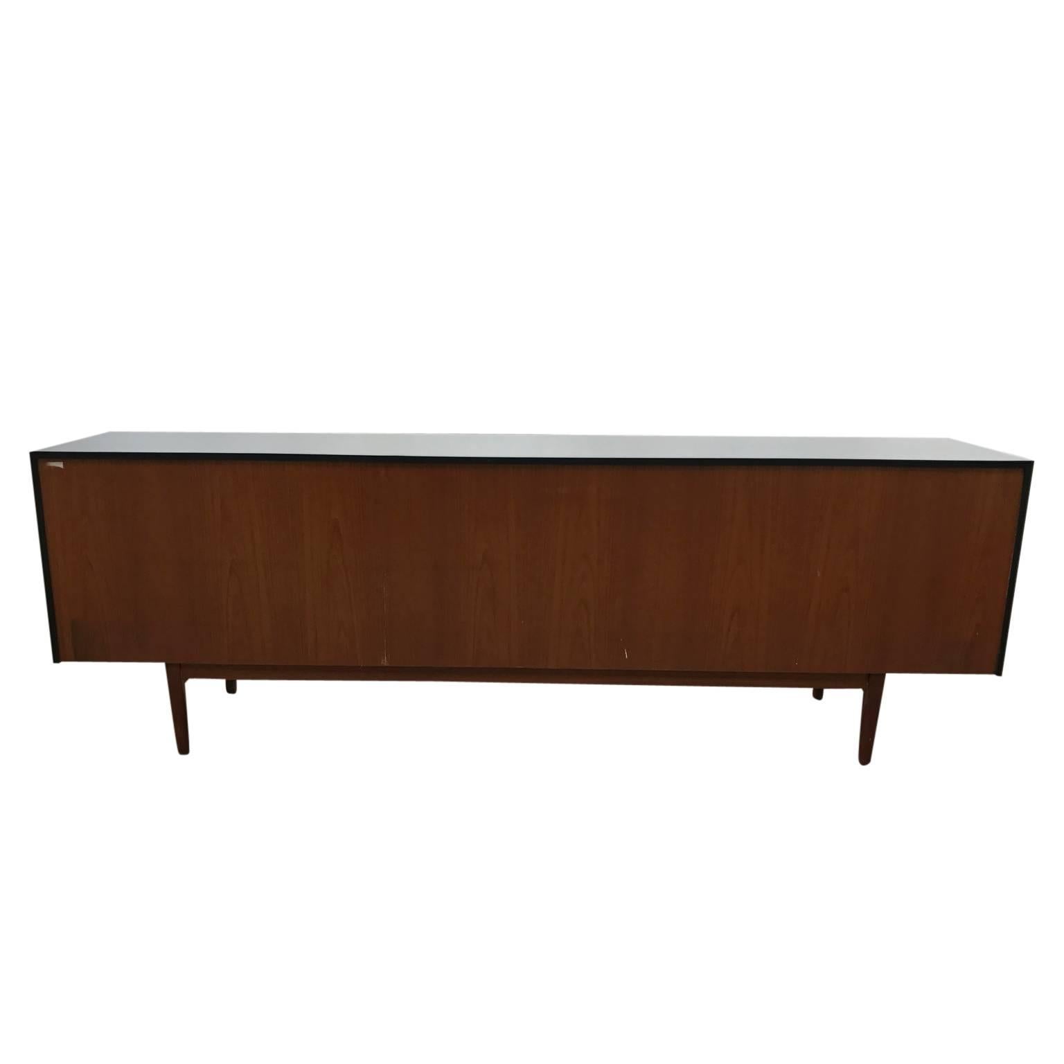 Danish Modern Ib Kofod-Larsen Danish Sideboard / Credenza in Teak and Charcoal. This Stunning sideboard / credenza features a bold two tone finish in deep charcoal and a light colored teak front. The top holds four drawers while the bottom has four