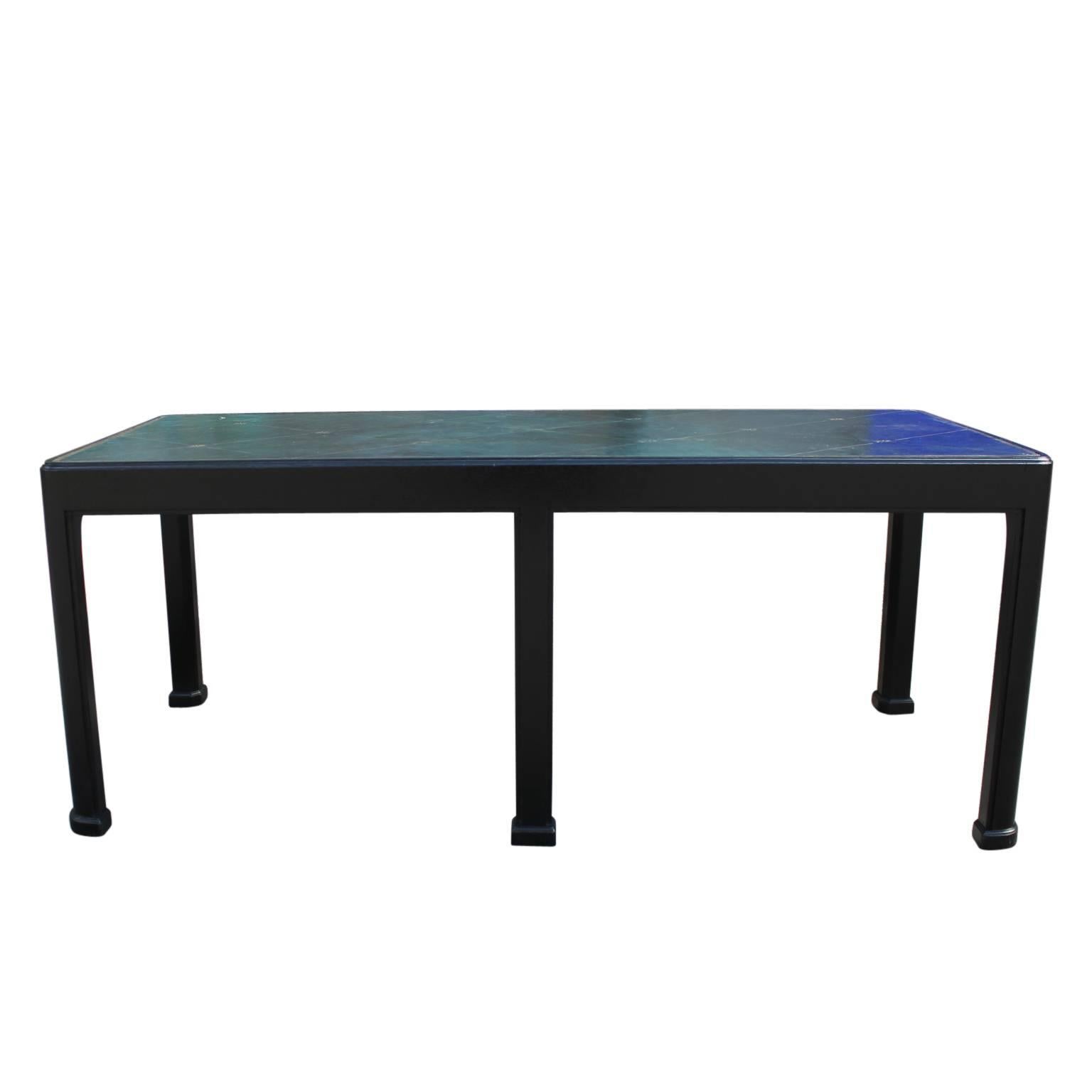Great 1940s Tommi Parzinger or Grosfeld House style coffee table with an ebony base and distressed blue-green leather top. The base has been restored while the top retains it's perfect patina. 