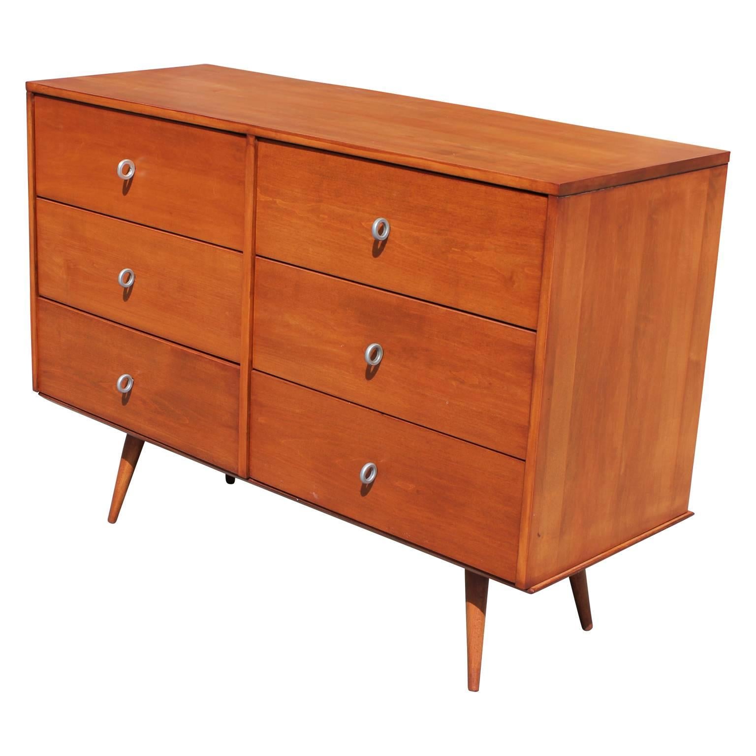 Pair of Mid-Century Modern maple wood dressers / chest of drawers by Paul McCobb for Planner Group. These pieces provides plenty of storage with six drawers and is fashioned with McCobb's signature aluminium pulls.