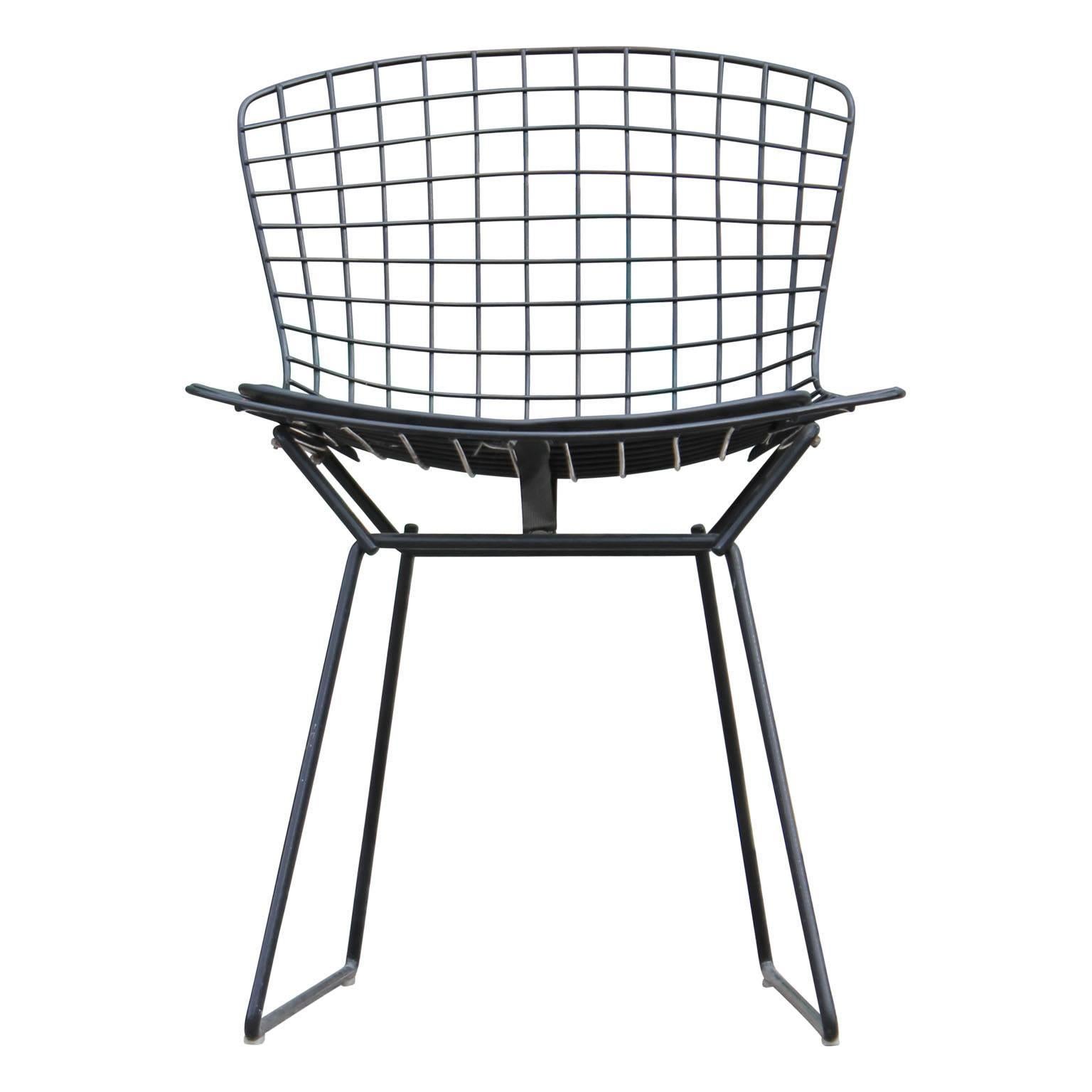 Set of four original black wire dining or side chairs by Harry Bertoia for Knoll. The fabric on the chairs is all original as well. Perfect for any mod, mid-mod or Hollywood Regency space.
