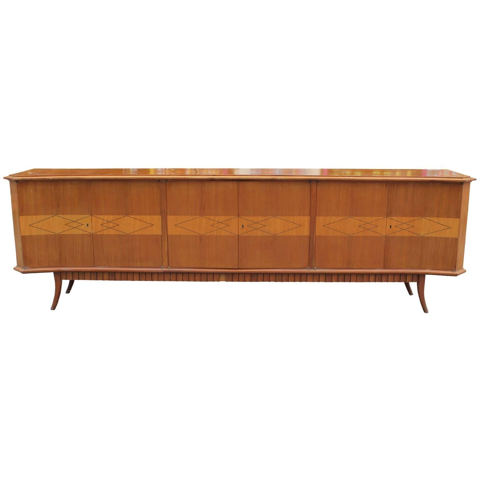 Fabulous, long Italian sideboard or credenza. Piece has incredible detailing. Front of sideboard is inlaid with an interlocking diamond motif. Six cabinet doors open to reveal a single shelf. Base is equipped with a dentil motif and two elegant