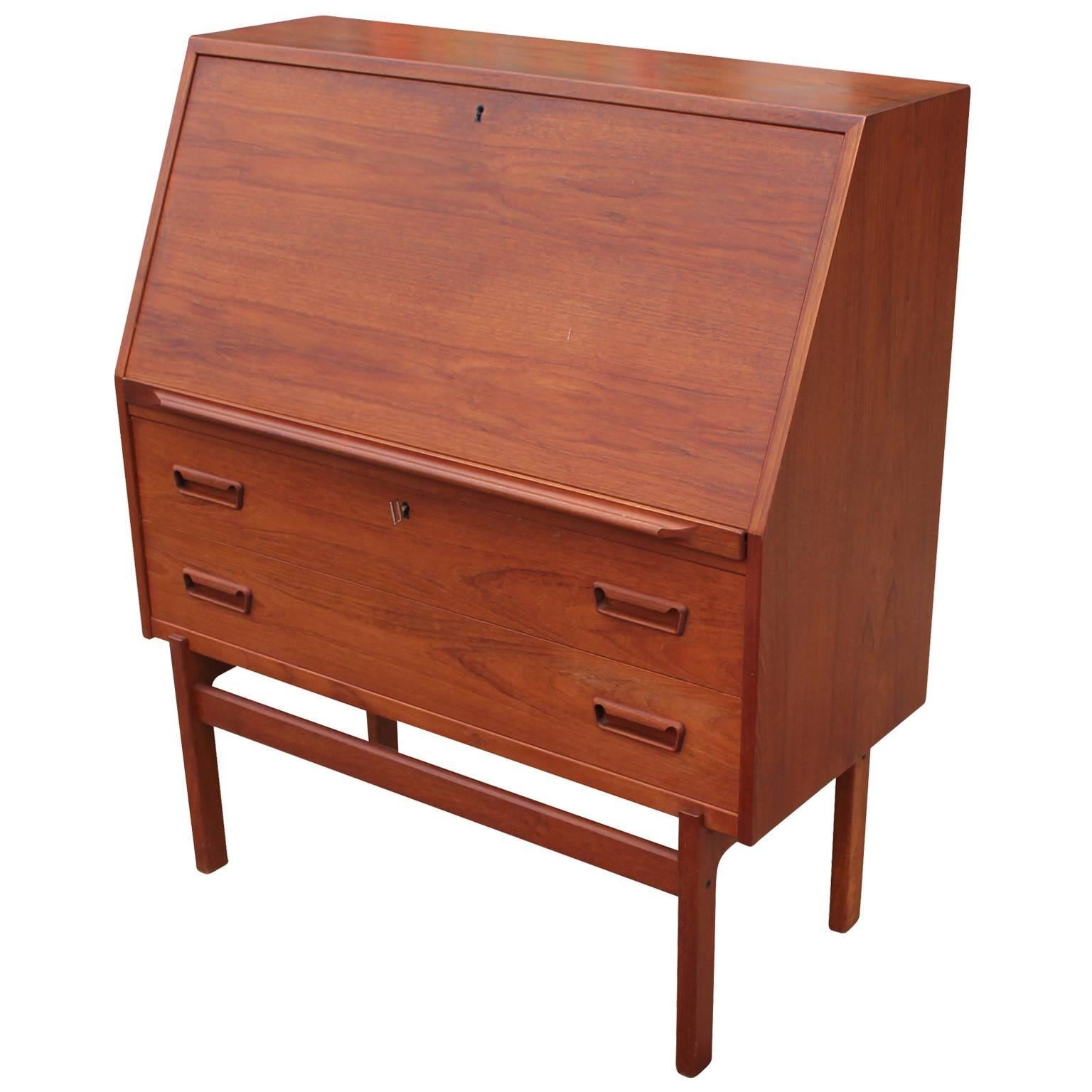 Beautiful 1960s Danish teak desk with a drop down front. Inside there is two drawers accompanied by dividers. The desk is in really nice vintage condition.