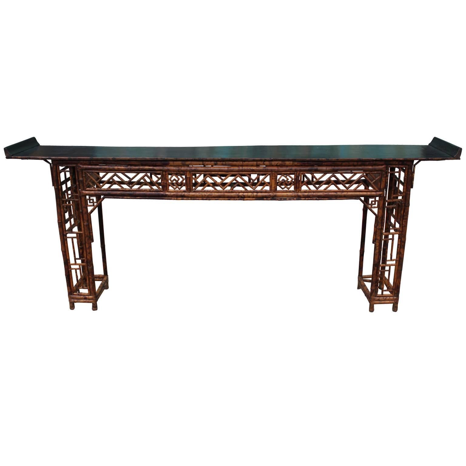 Elegant Chinese bamboo altar table. Base is constructed with an elaborate geometric design, below rectangular inward scrolling black lacquer top. Great as a console table. 