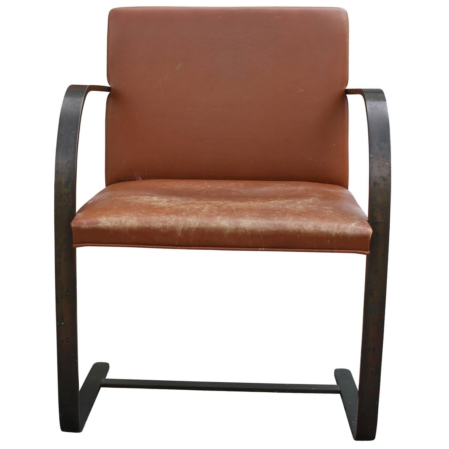 Stunning side chair in by Ludwig Mies van der Rohe Knoll. Chair is upholstered in caramel brown leather with the perfect patina. Cantilevered bronze flat bar base with an excellent patina.