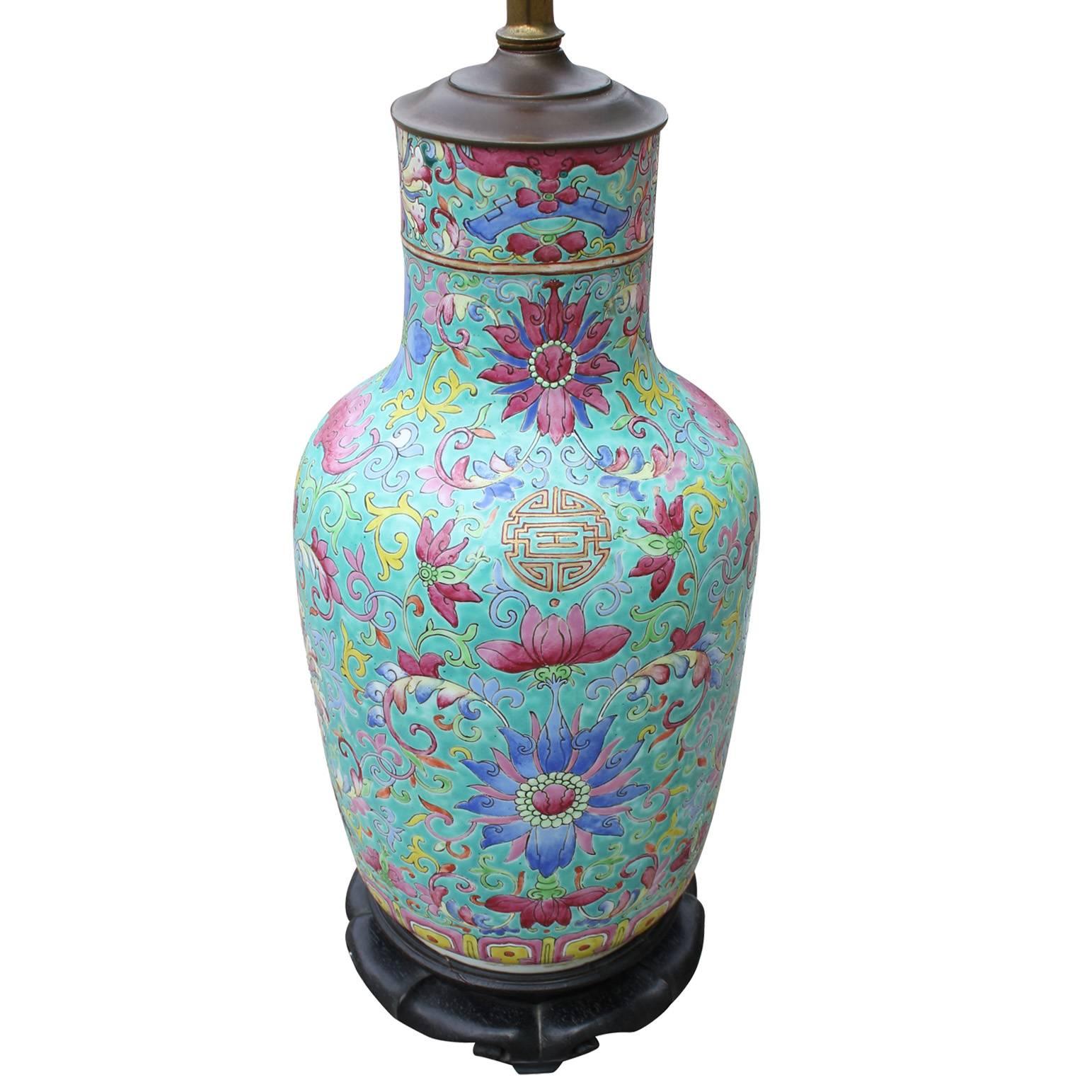 19th century Chinese vase wired as a lamp on a vintage base. Lamp is exceptional with vivid shades of turquoise, pink, blue, and yellow. Decorated with an intricate floral motif. 