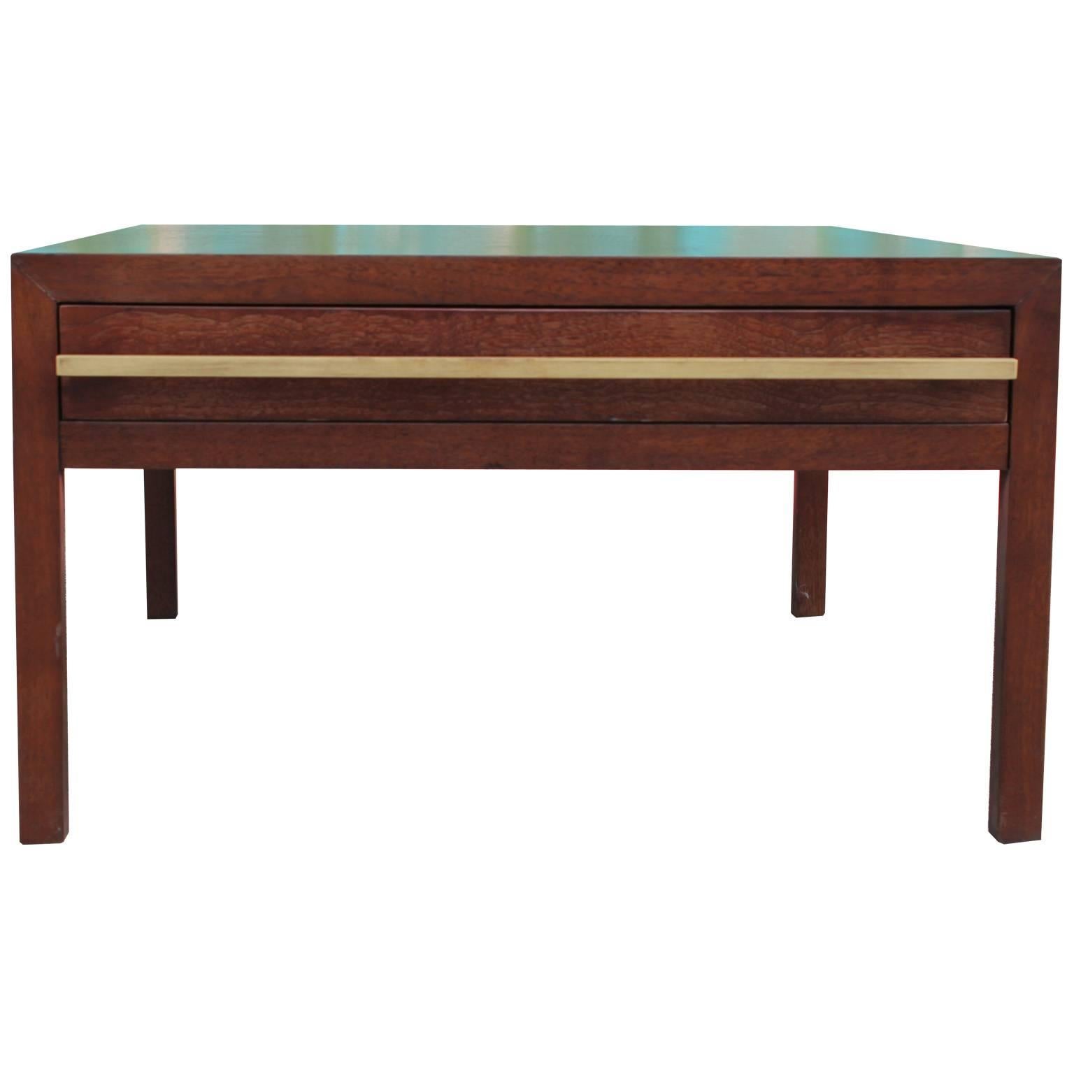 Excellent coffee table or occasional table by Michael Taylor for Baker. Table has simple clean lines. A single drawer provides storage. Dramatic brass hardware adds visual interest.