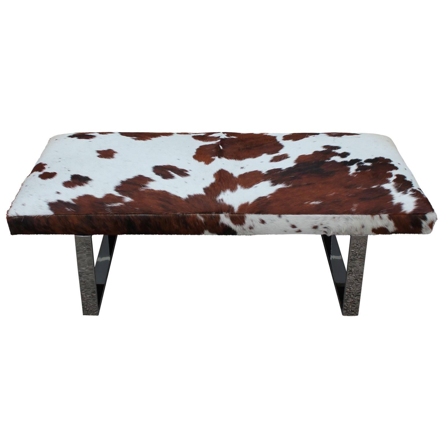Gorgeous custom bench or ottoman with shiny chrome legs. Bench is topped with silky cowhide in brown and white. 