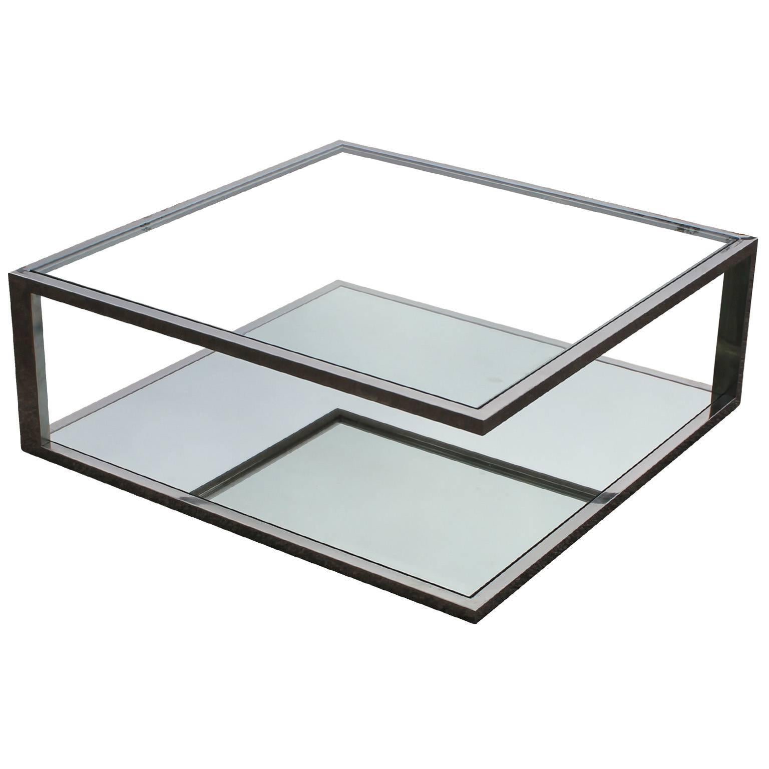 Wonderful angular modernist Chrome, Mirror, and Glass coffee table. The table is well constructed and adds interest from all angles. The top is supported by two chrome bars. The top is clear glass and the bottom is mirrored glass. In excellent