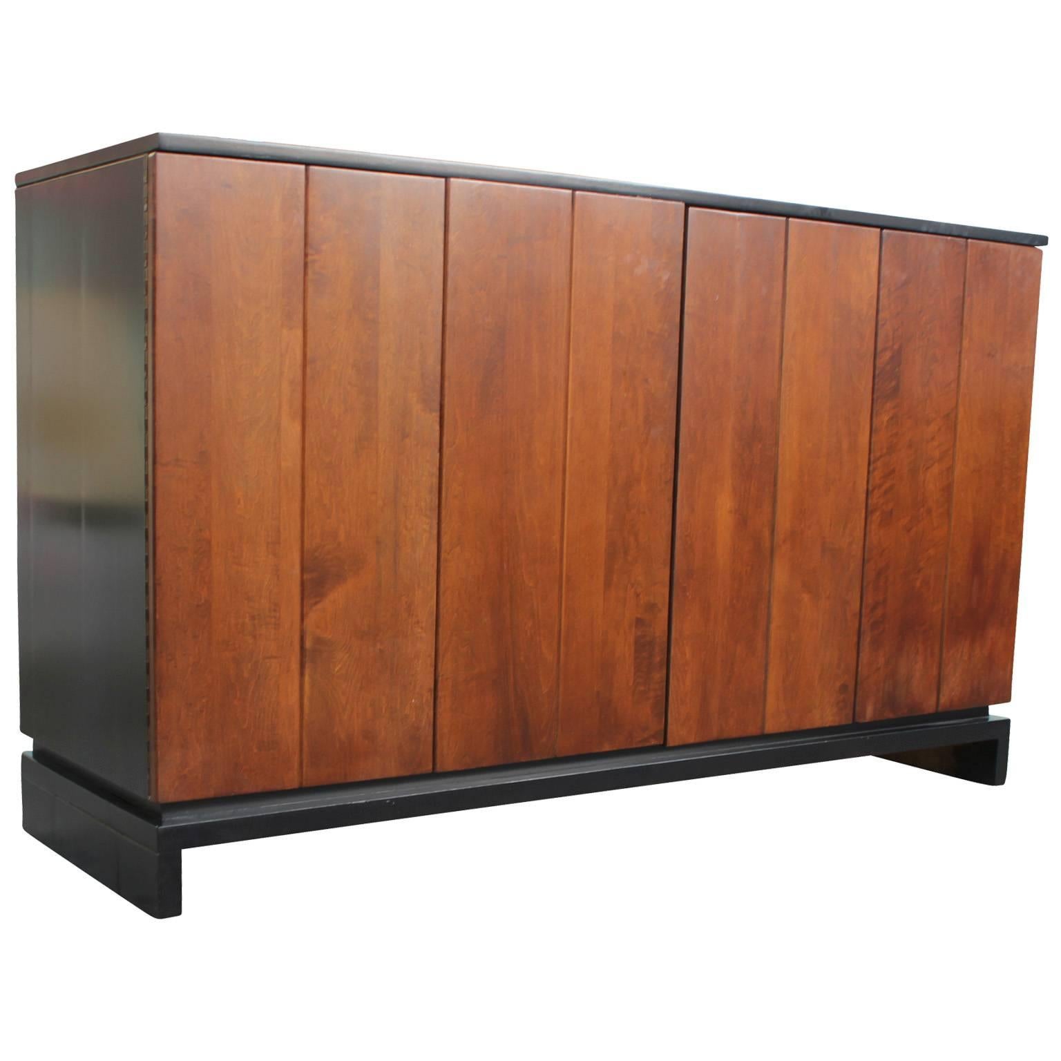 Stunning buffet/ sideboard/ cabinet designed by Hendrik Van Keppel and Taylor Green for Brown Saltman. Bi-fold doors reveal shelved storage and five drawers. Piece is freshly refinished-case in ebony and doors in a medium walnut. 