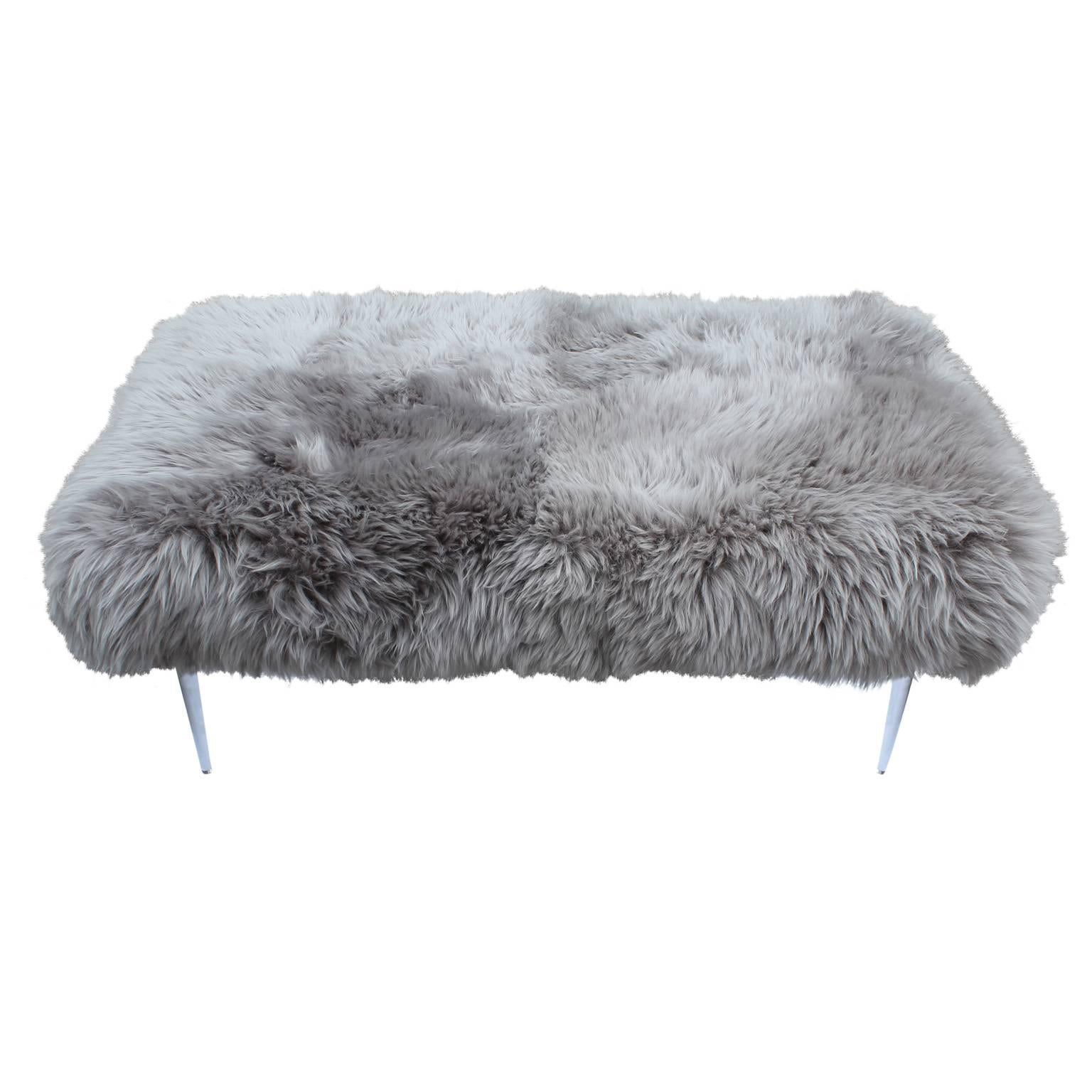 Luxe custom made bench or ottoman-perfect in place in of a coffee table. Piece is topped in ultra plush sheepskin in grey and finished with tapered lucite legs. 