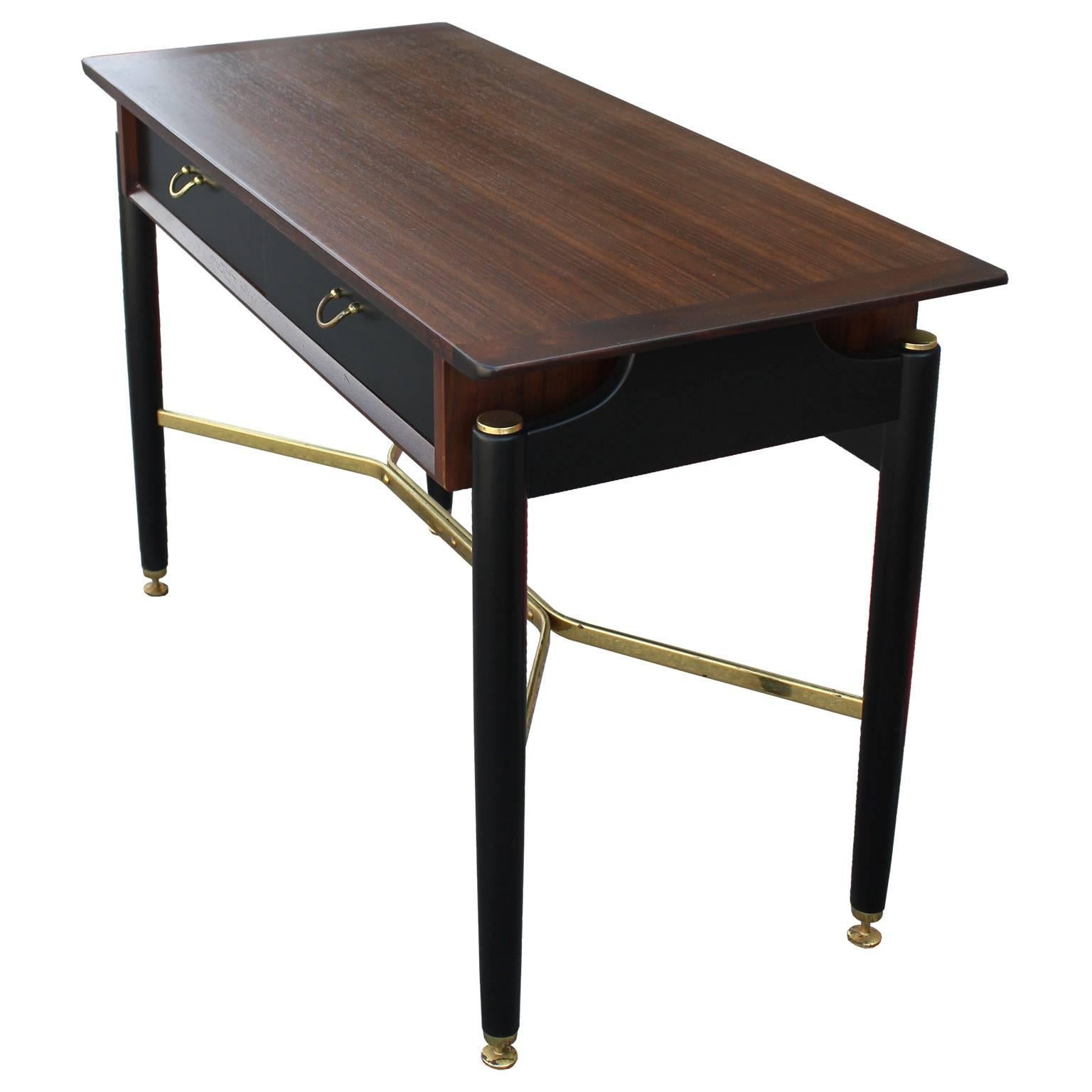 Gorgeous console or entry table finished in ebony with medium walnut accents. Two drawers provide storage. A shiny brass stretcher adds visual interest to the piece. Brass levelers, caps, and pulls complete the console. Would be great as a desk also.