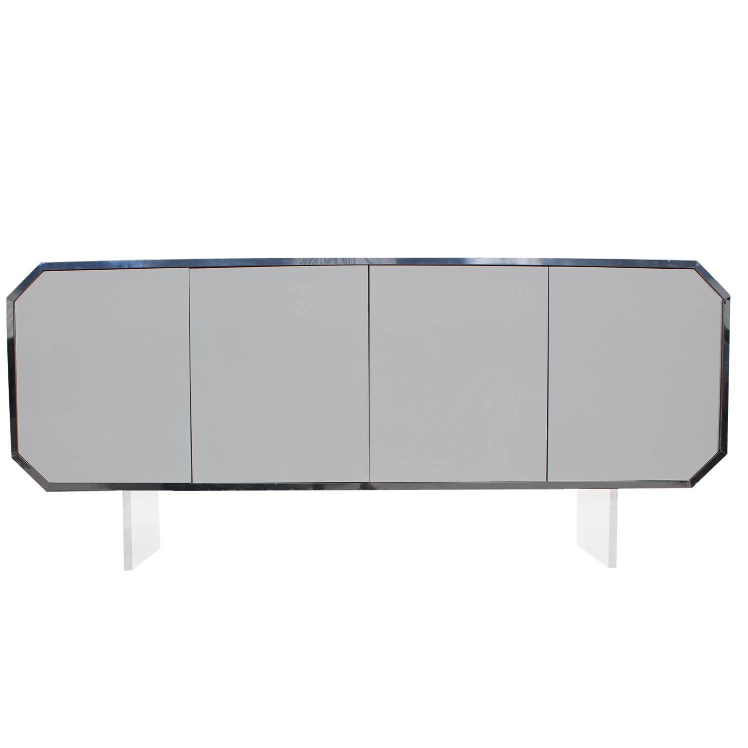 Stunning octagon shaped credenza with thick Lucite legs and chrome accents. The sideboard or cabinet was probably custom built in the 1970s. The chrome trim band gives the piece a wonderful finished detail. The inside includes a door and lots of