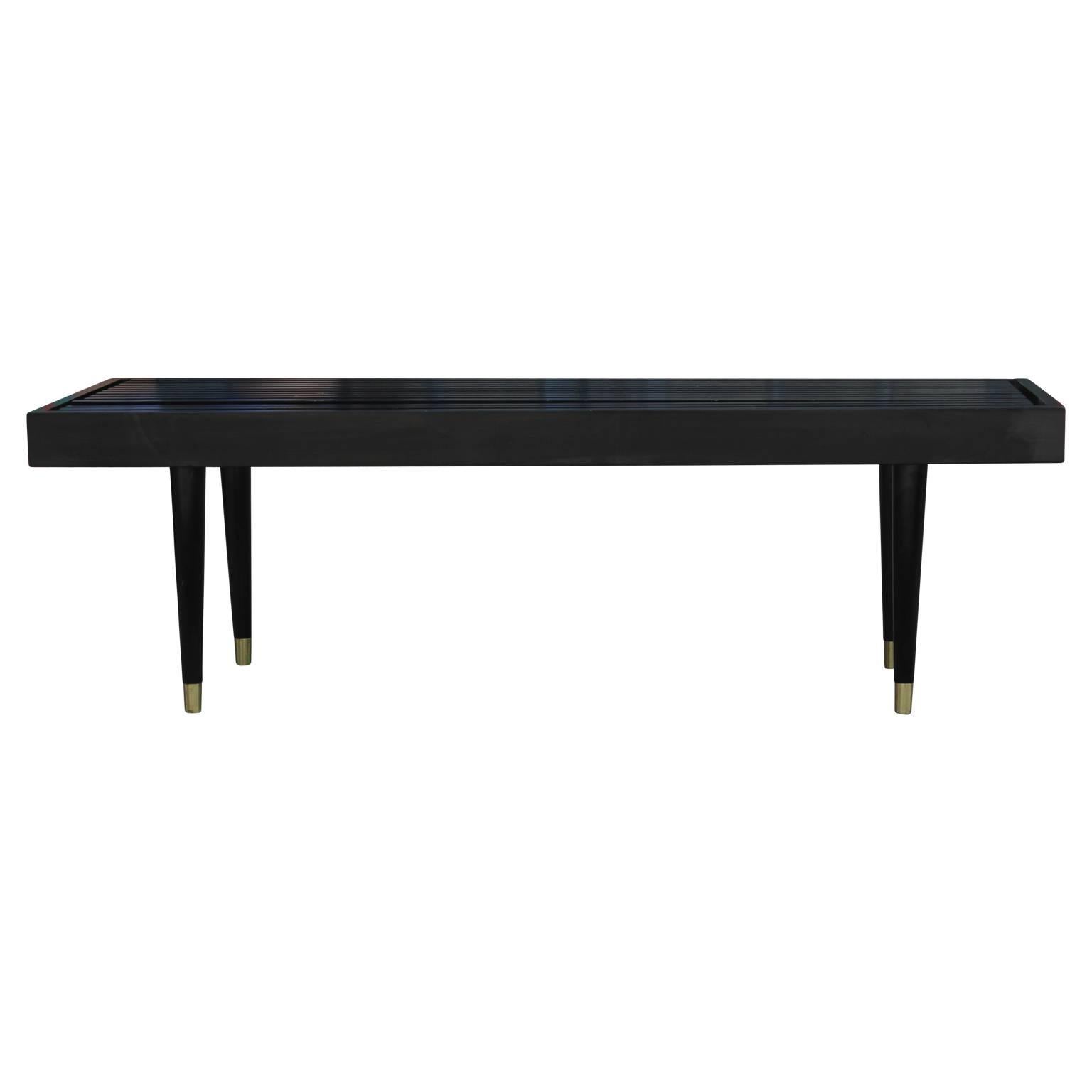 Mid-Century Modern black slat bench attributed to George Nelson with brass feet. There is also a second one available.