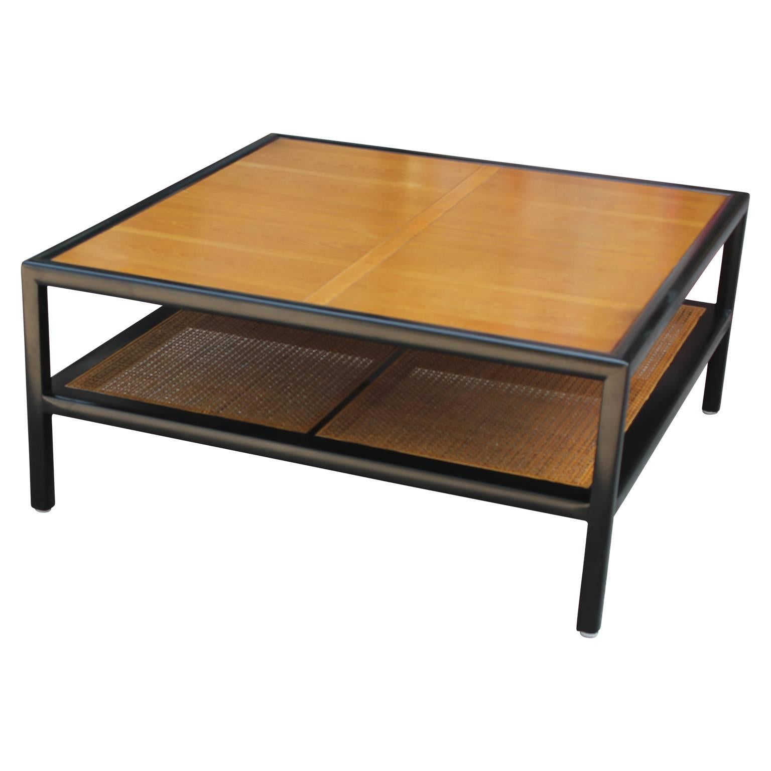 Unique two-tone coffee table by Michael Taylor for Baker Furniture Co. with a woven cane shelf as part of their New World Group line.
