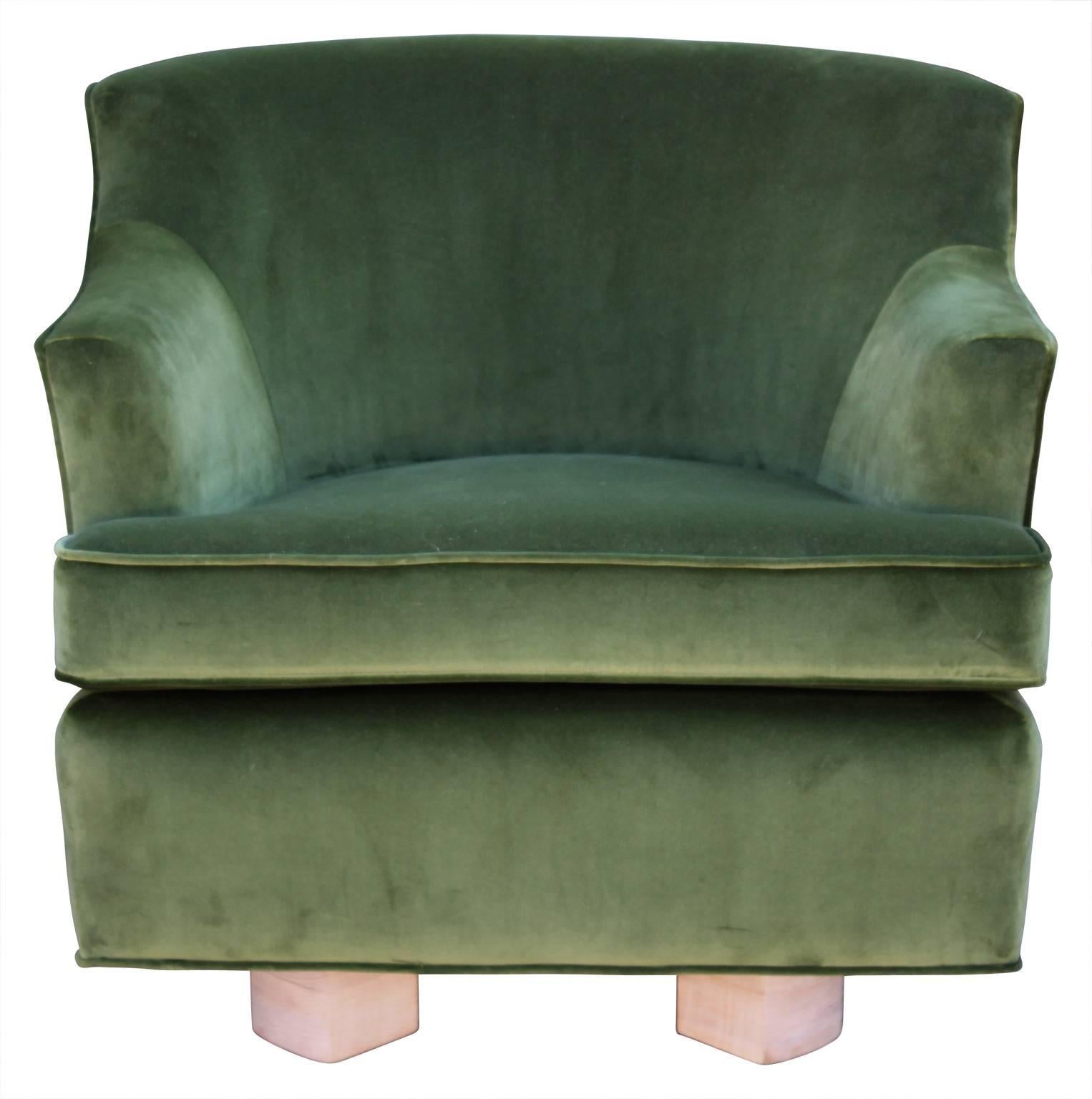 Unique swivel lounge chair with a bleached wood base and upholstered in deep green velvet in the style of Grosfeld House.