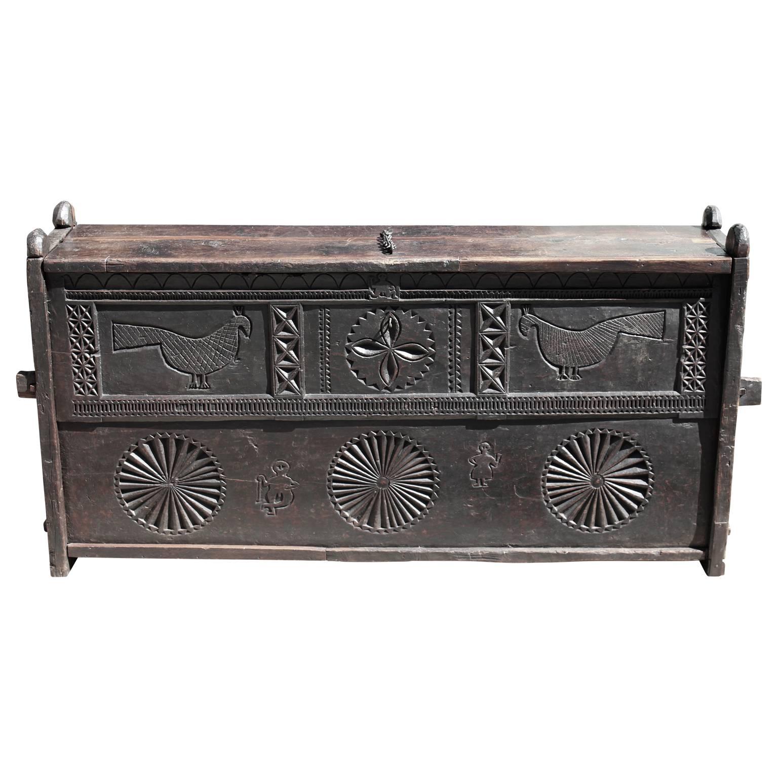 Gorgeous 17th century Jacobean colonial oak chest with hand-carved birds. This piece was constructed with tongue grooves and features large ball feet.