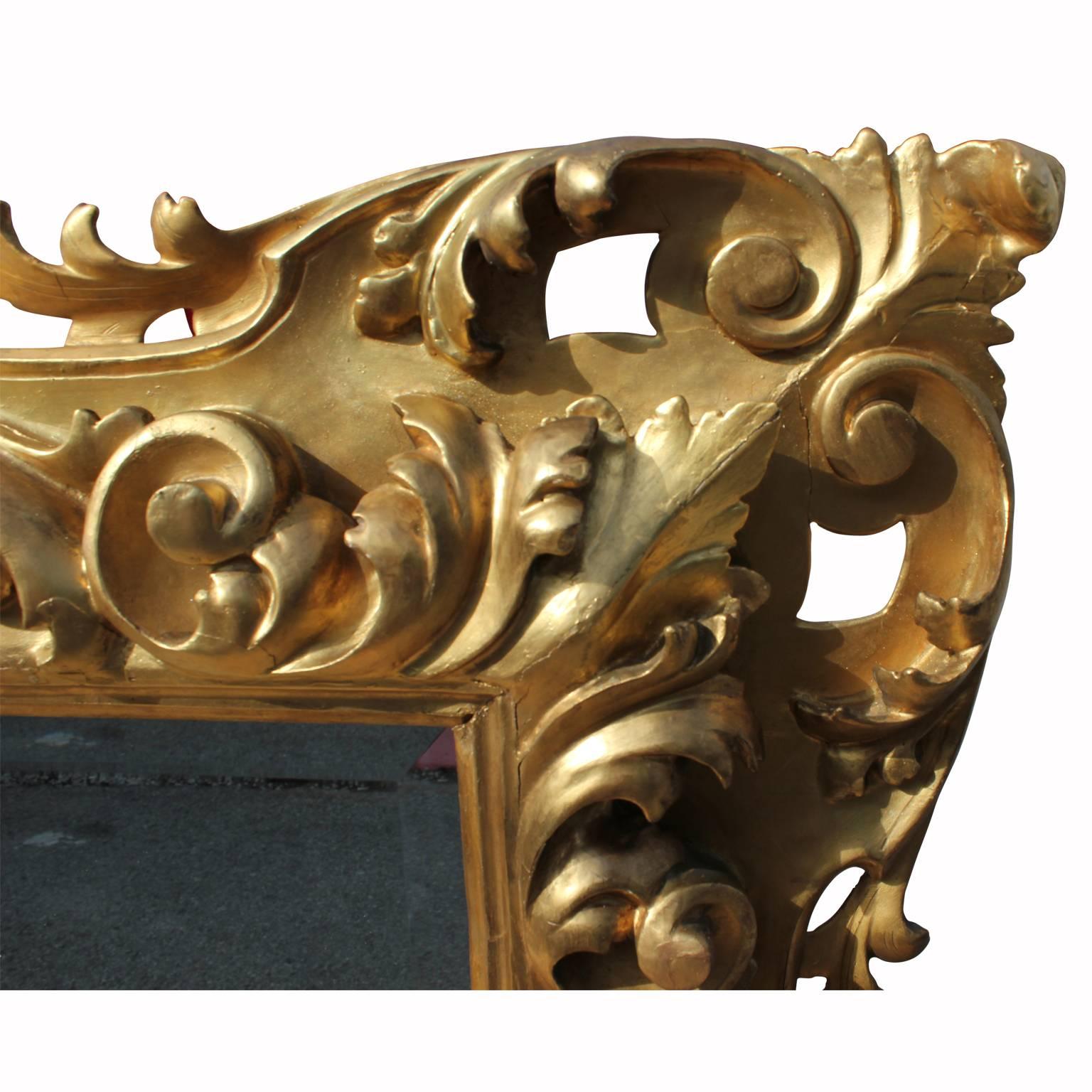 Monumental ornate French gold gilt mirror. Beautifully hand-carved from late 18th century to early 19th century. Features beveled glass and carved floral motifs.