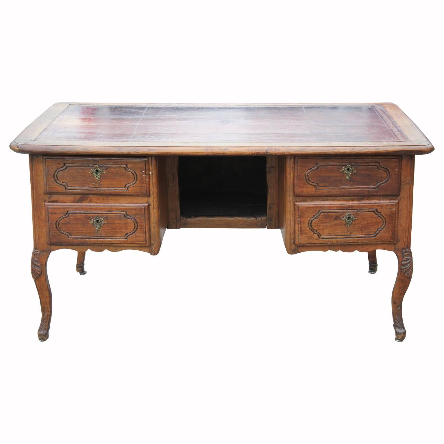 Gorgeous 18th century Louis XV leather top French desk with carved detailing and cabriole legs made from either walnut or fruitwood. Masterfully crafted with all peg work, no screws. In magnificent unrestored condition.