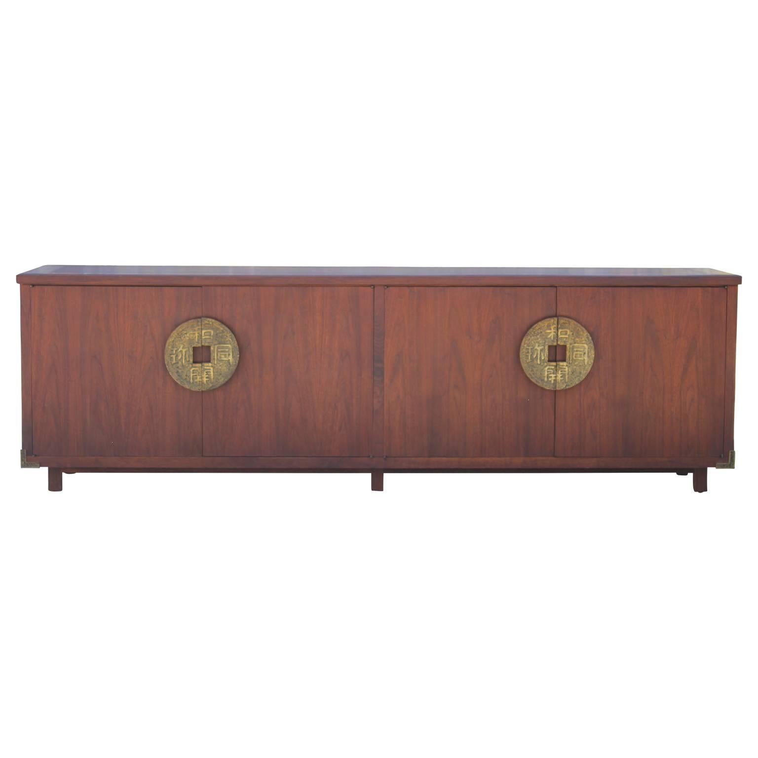 Custom-made clean walnut credenza or sideboard with heavy Chinese coin brass hardware by Houston's finest 1960s custom furniture designer -Evan's Monocle. Brass has a lovely patina.  Cabinet doors open to reveal a variety of drawers, as shown in the