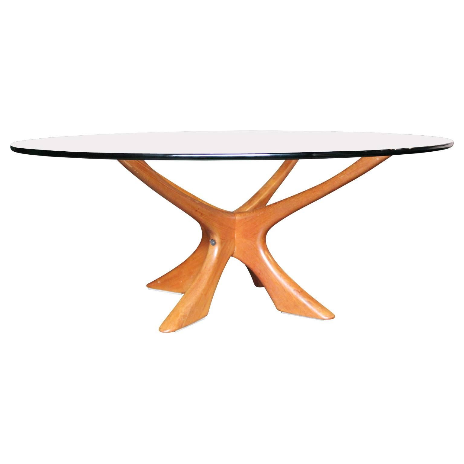 Unique Illum Wikkelsø round glass top coffee table with a sculptural teak base. The glass detaches from the base making it easily transported. Perfect for any modern or mid-mod space.