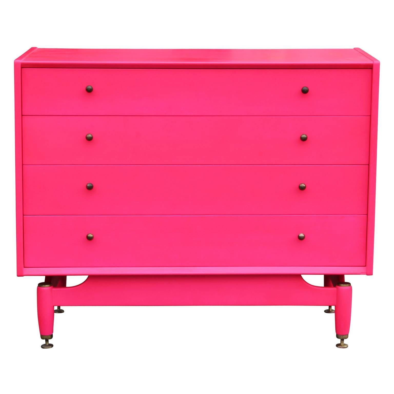 Gorgeous four drawer chest of drawers by G Plan, freshly waxed in a vibrant pink and with brass hardware. In the style of Dunbar. The top drawer is divided into three sections, making it easy for organization. A perfect statement piece to any room. 