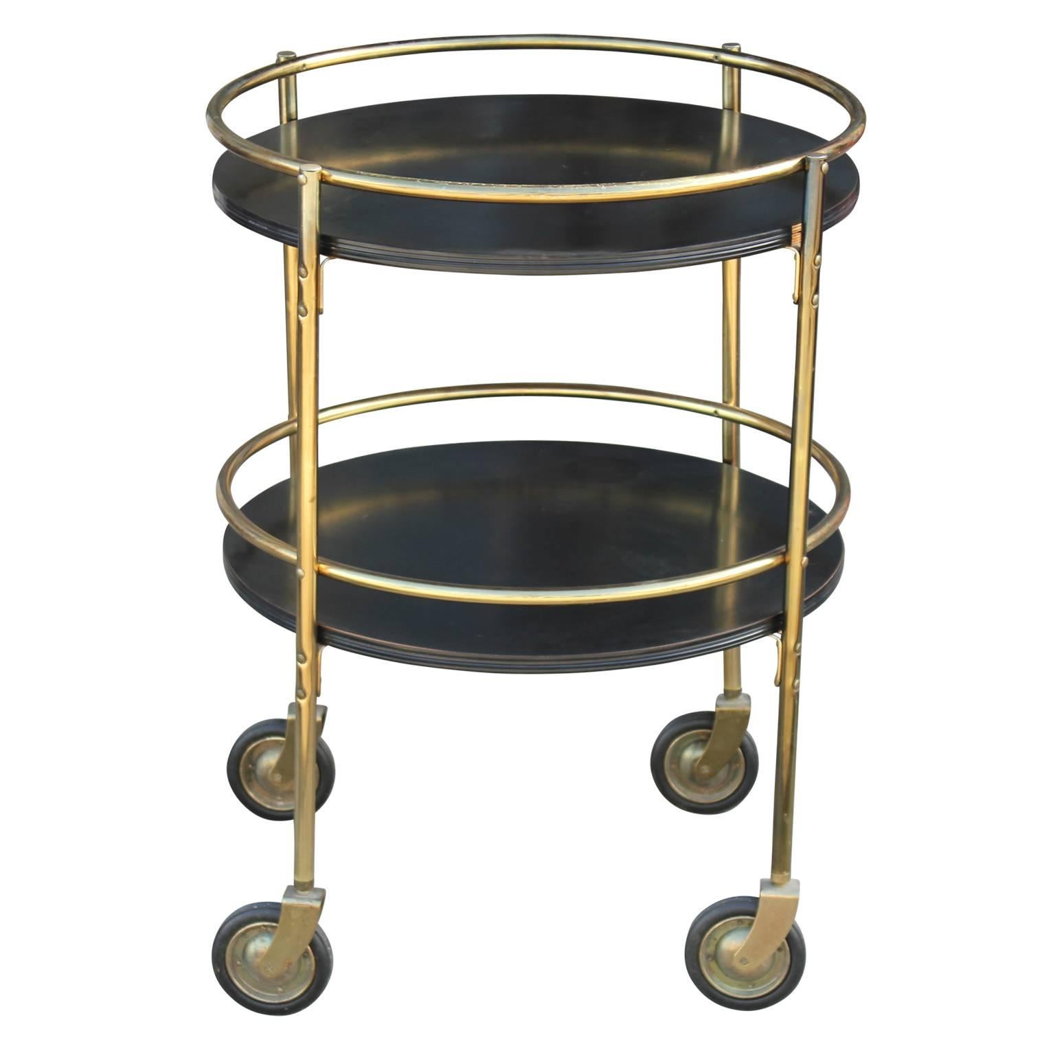 Modern round two tiered bar cart in a lovely black with a brass structure with a perfect patina. In the style Kem Webber. The contrast between the black and brass provide a dynamic. Gorgeous and functional. 