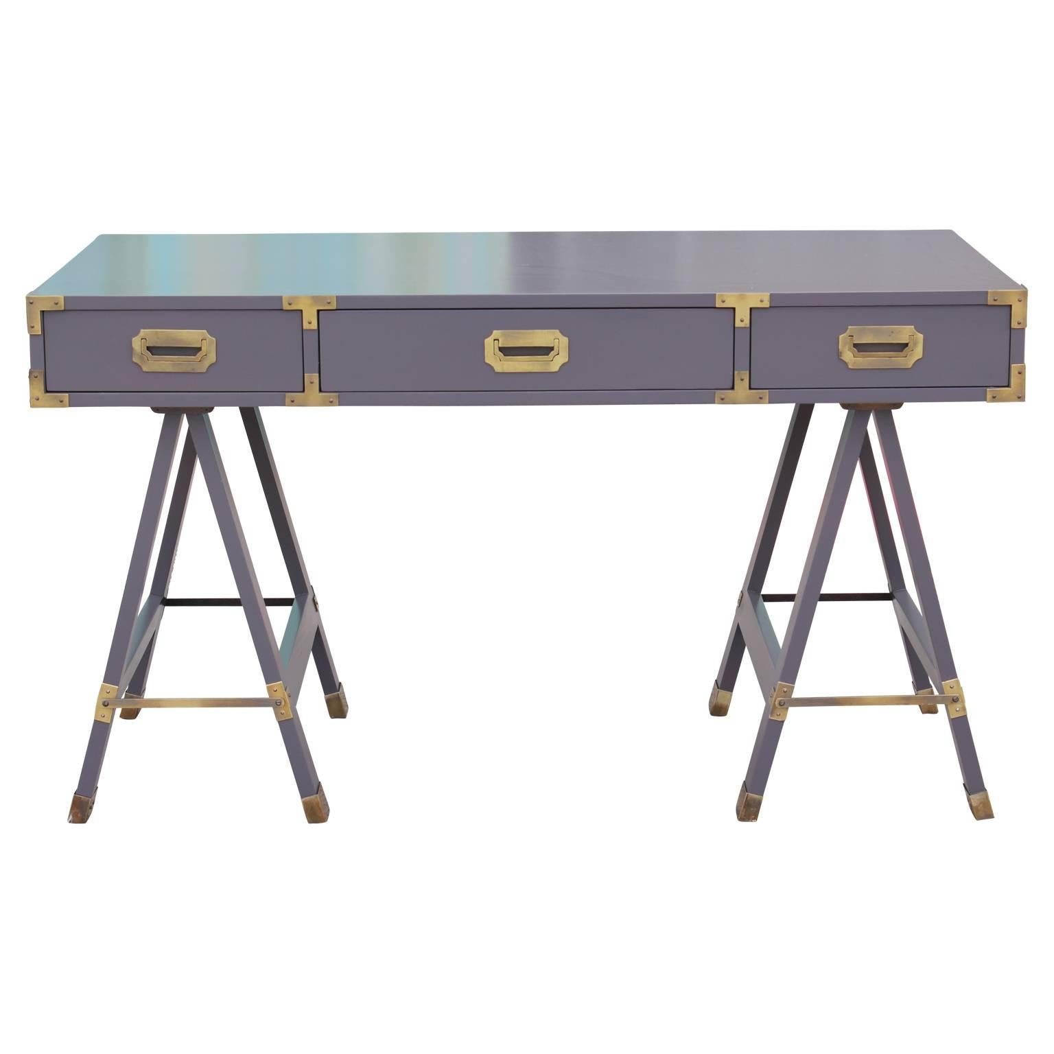 Beautiful Campaign desk in the style of Baker furniture. Freshly lacquered in a deep grey and with brass detailing with a lovely patina. Features three drawers in the front and faux drawers on the side with brass detailing as well. Could be used as