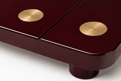 Mesa de centro «Domino» de Alexandre Ligios, con diseño escultural en laca burdeos y latón