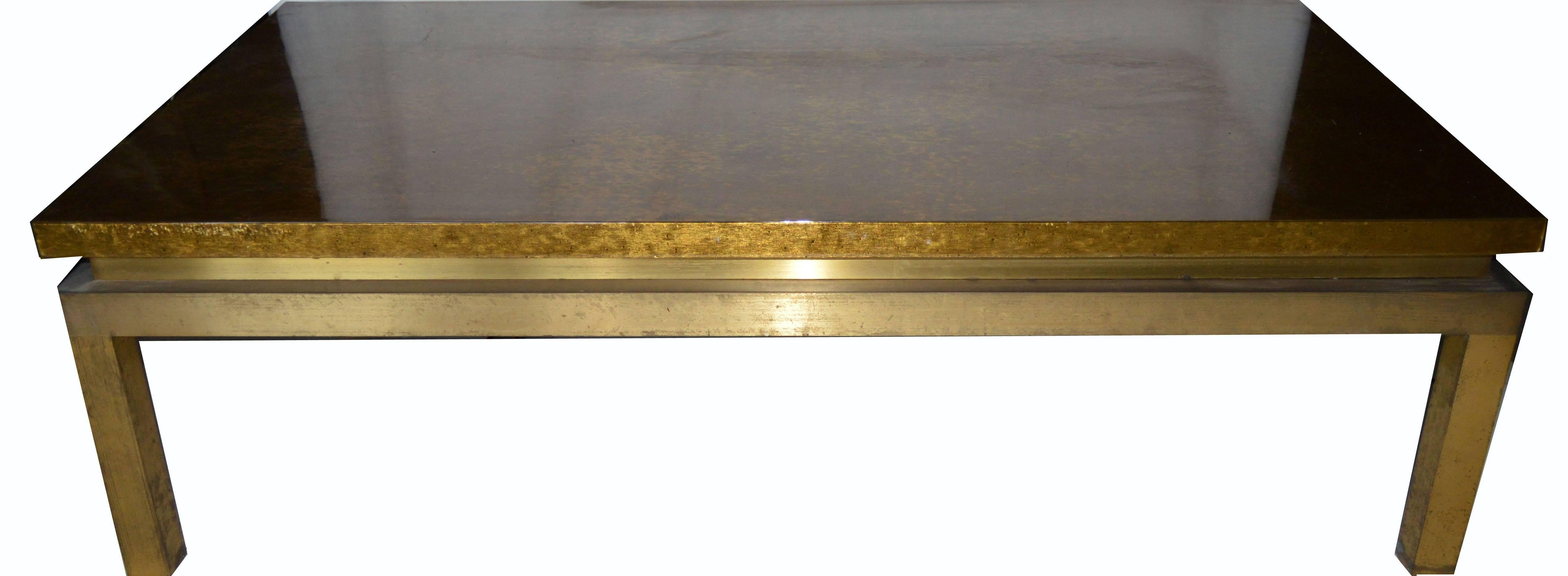 Superb coffee table by Maison Jansen, gold leaf on wood top with a thick clear lacquer, bronze frame and legs.