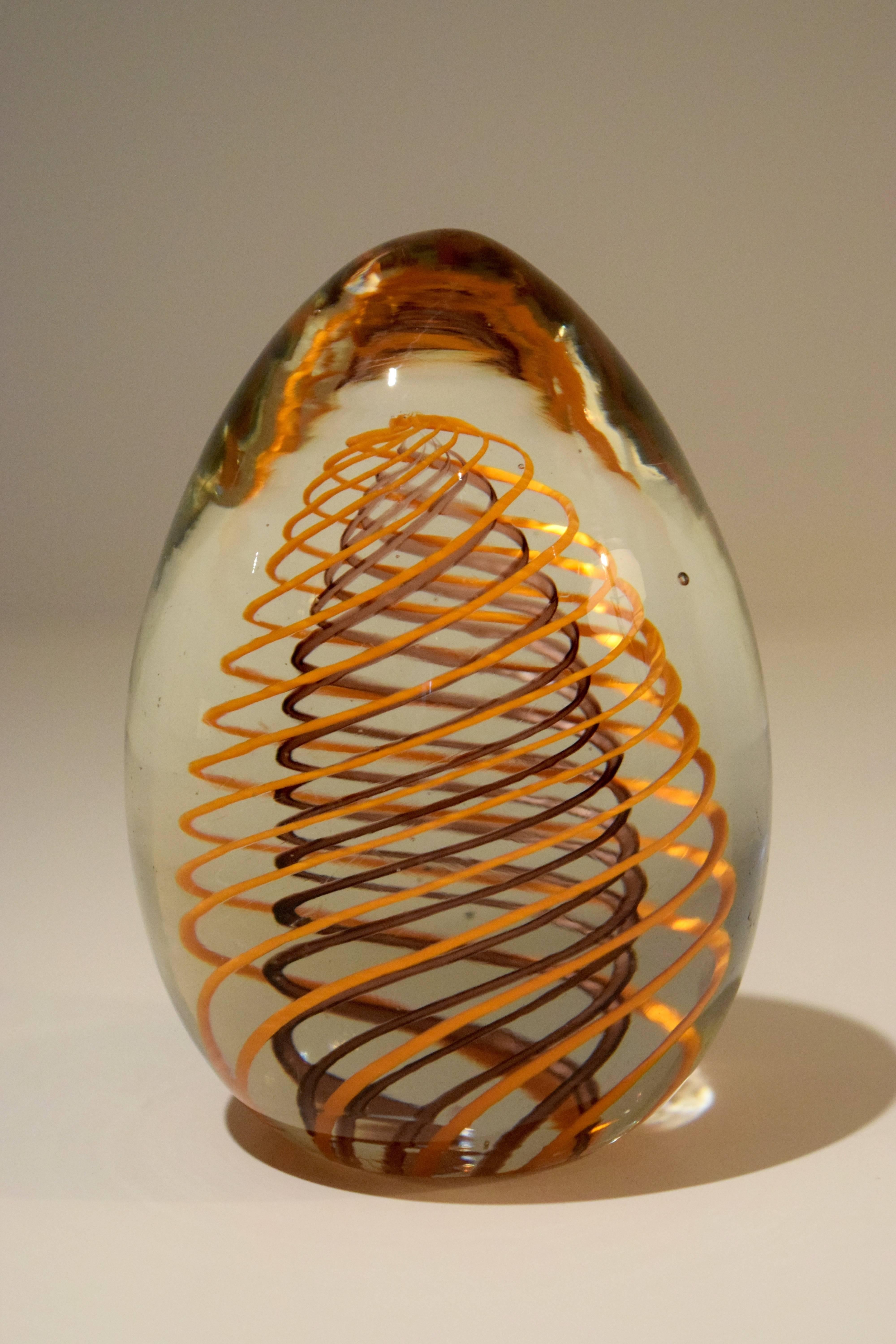 This egg-shaped Venini glass paperweight has a purple spiral encased in an orange spiral.  It still bears the original Venini label with the Veronese vase printed in silver on a yellow ground, which dates the paperweight to the 1960s.