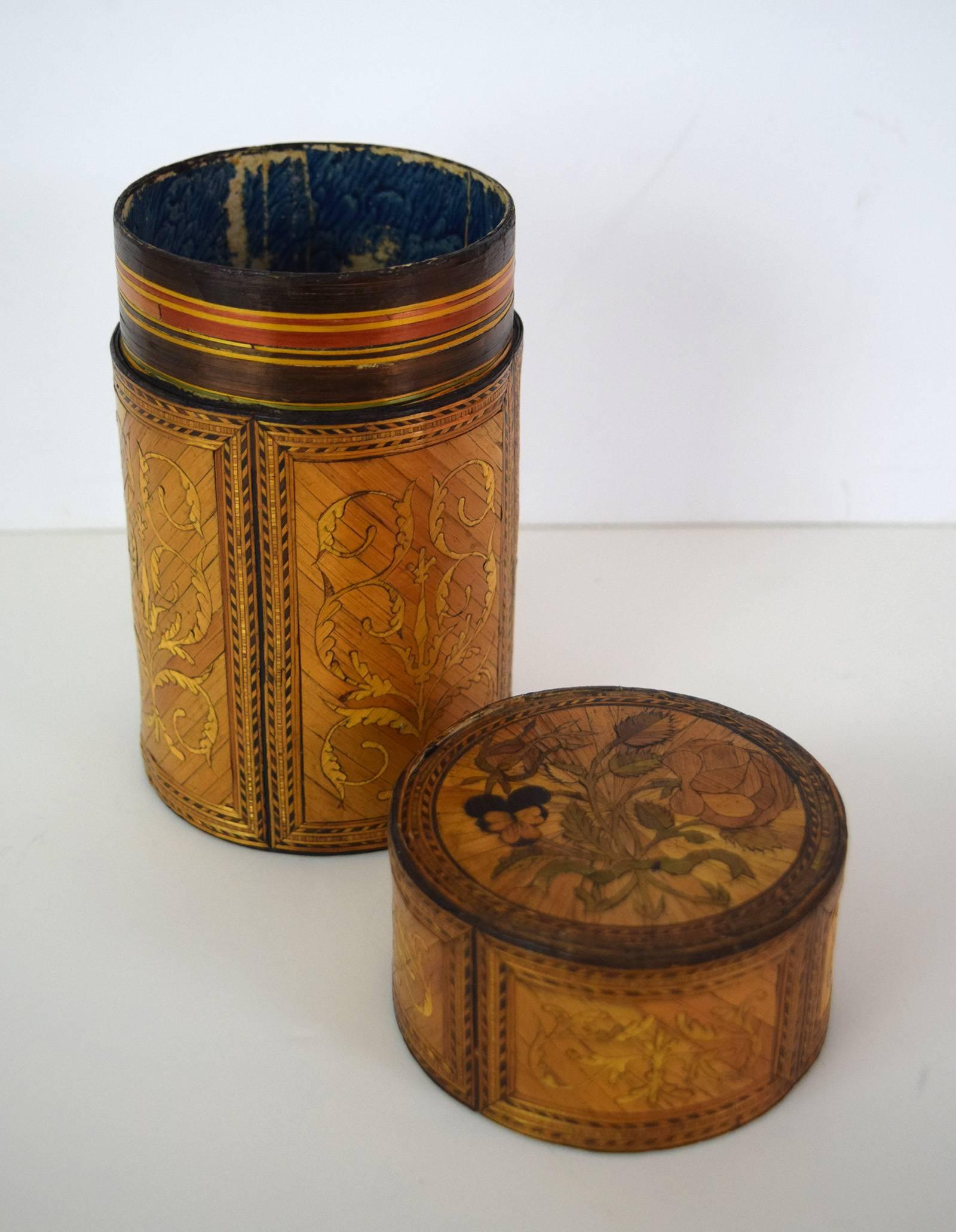 This cylinder box is an exceptionally fine example of straw marquetry, and a rare survivor of the craft, which involves the cutting, coloring, and mounting of split straws to form decorative patterns.  The craft flourished in what would have been