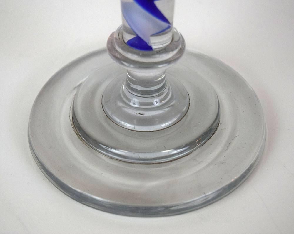 This large and dramatic blown and cast-glass candlestick, with a blue-and-white spiral in its stem, was most likely made in England around 1800.  It comes from the collection of the legendary aesthete Baron Max Fould-Springer, who lived at the