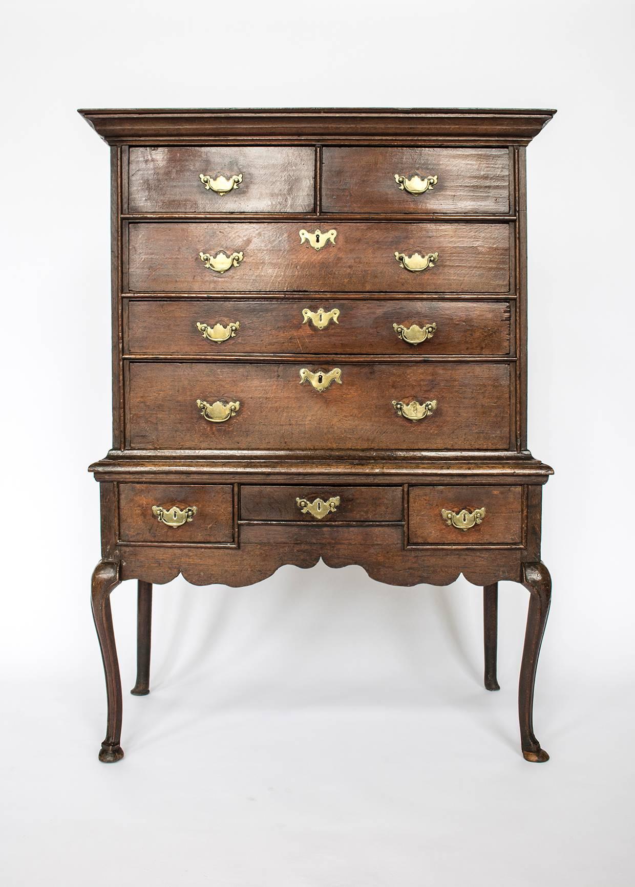 Lovely oak chest on stand featuring brass handles and Queen Anne style cabriole legs. 

Condition is fair with some notes; replacement handles, some old repairs, some old worm holes, bail missing from stand central drawer.