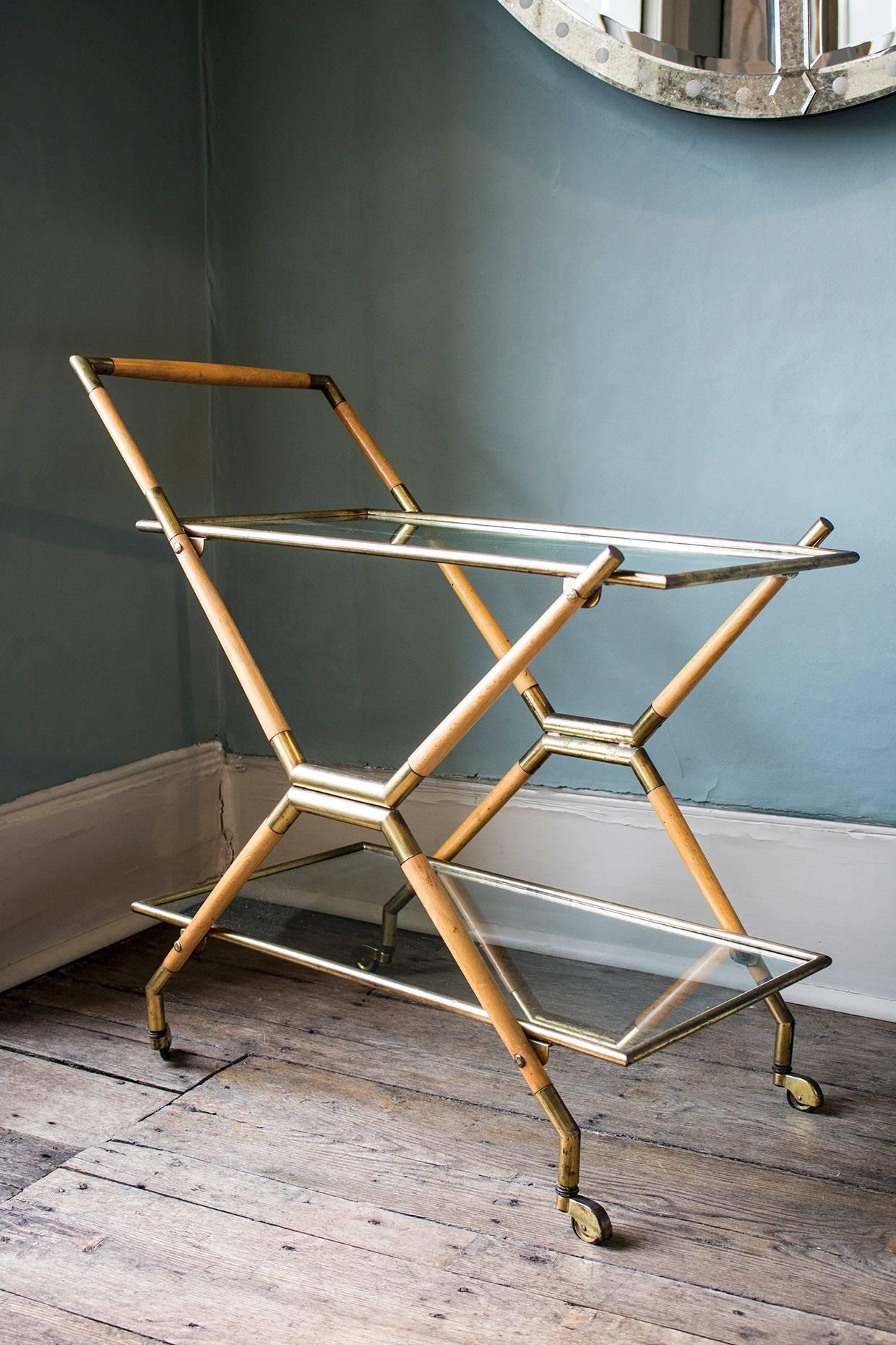 Bar cart/drinks trolley in glass, brass and wood,
circa 1950s.