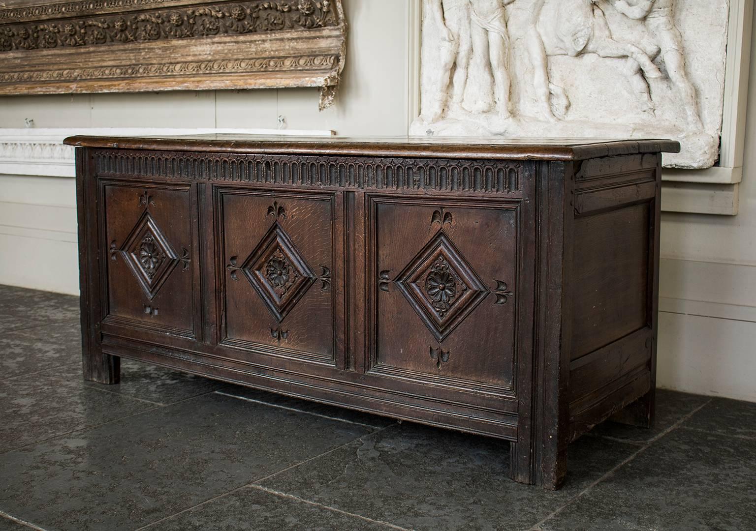 An 18th century oak coffer with carved panels and decorative carved frieze and raised on shaped foot supports, and with hinged top.

Please enquire about international shipping.